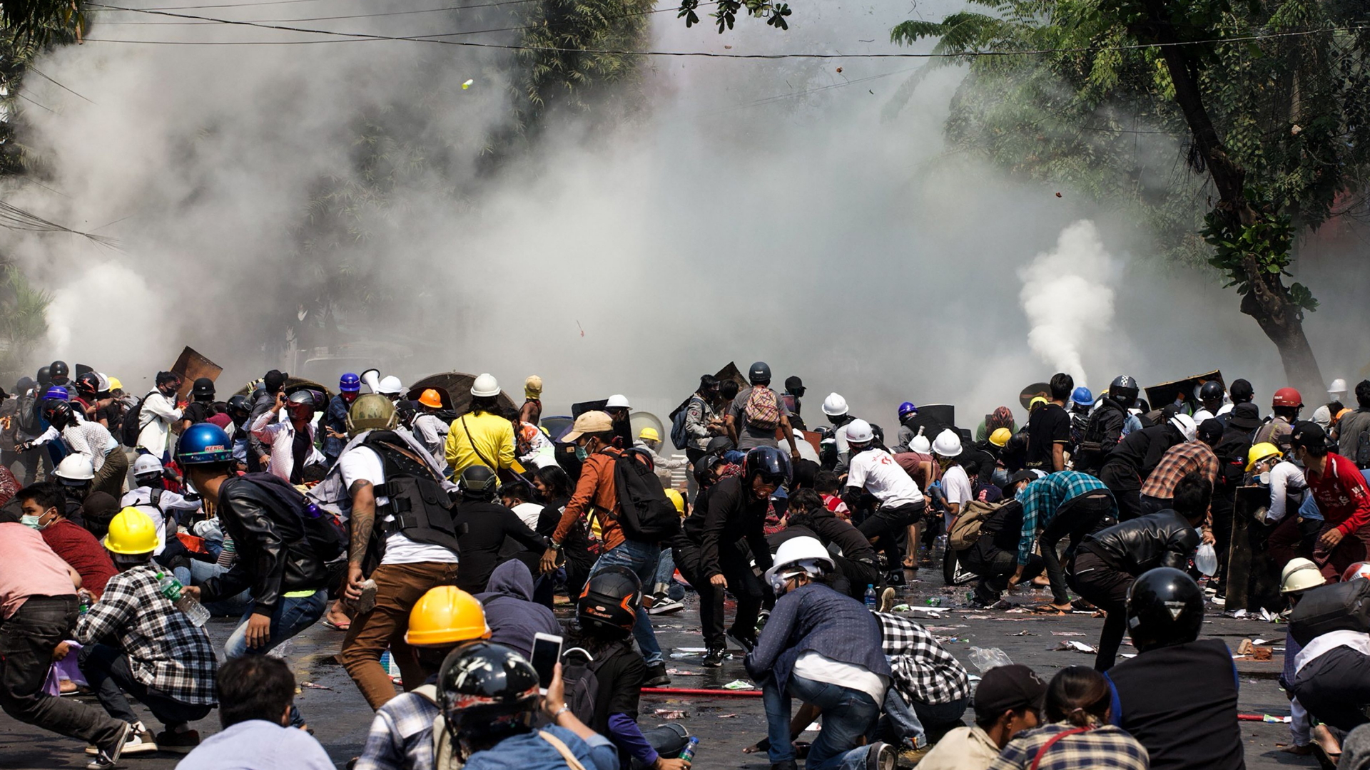Demonstrierende in Mandalay werden von Sicherheitskräften mit Tränengas beschossen. | AFP