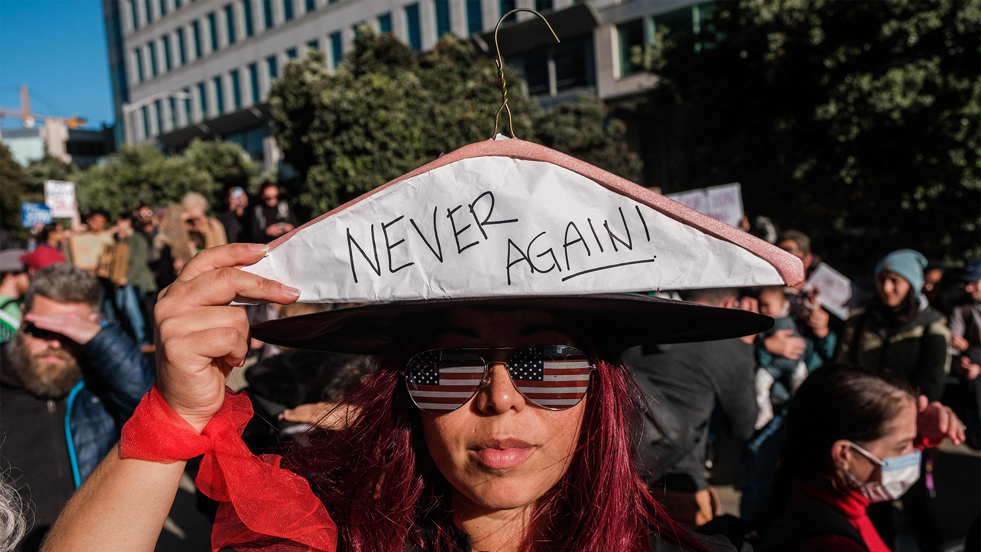 Eine Demonstrantin hält einen Kleiderbügel hoch mit der Aufschrift „Nie wieder“, während sich Pro-Choice-Demonstranten vor dem Bundesgebäude in San Francisco versammeln. | AFP