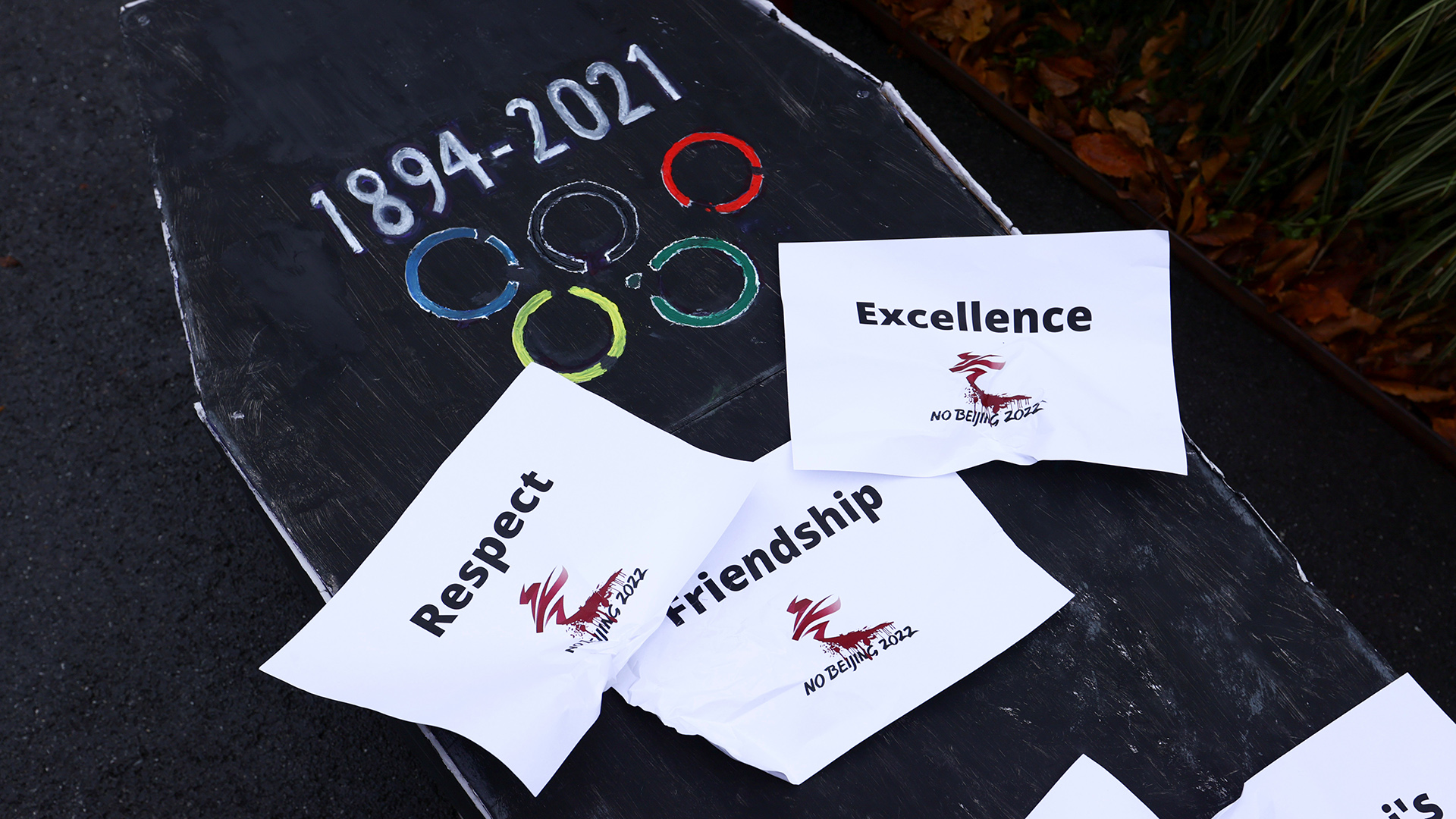 Eine Protestinstallation zeigt einen Pappsarg mit dem Olympiasymbol und Werten. | REUTERS