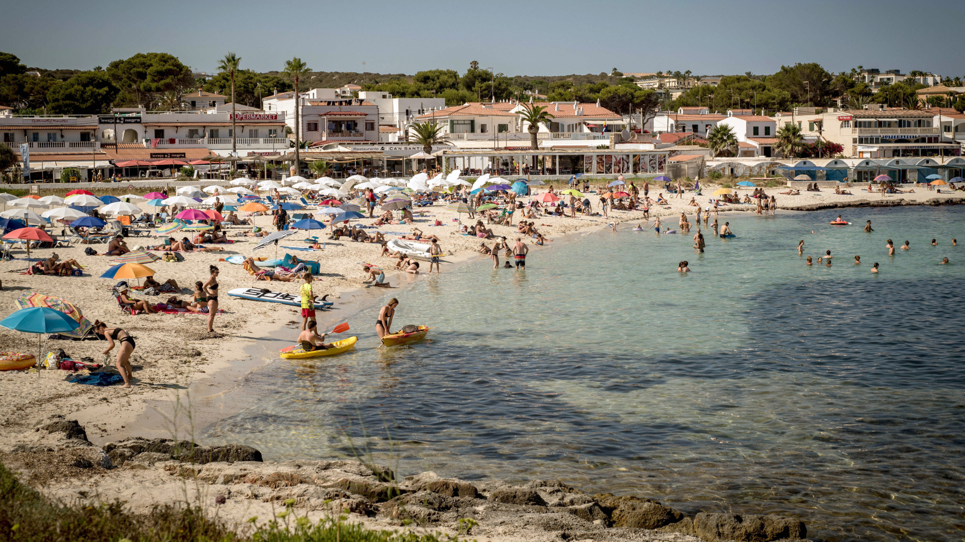 Urlauber kühlen sich am Strand von Punta Prima in Sant Lluis auf Menorca ab.