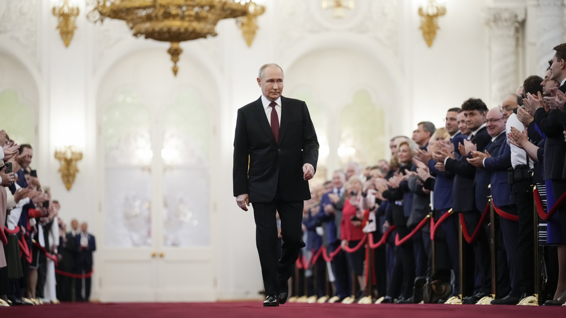 Wladimir Putin geht an einer applaudierenden Menschenmenge im Kreml vorbei.