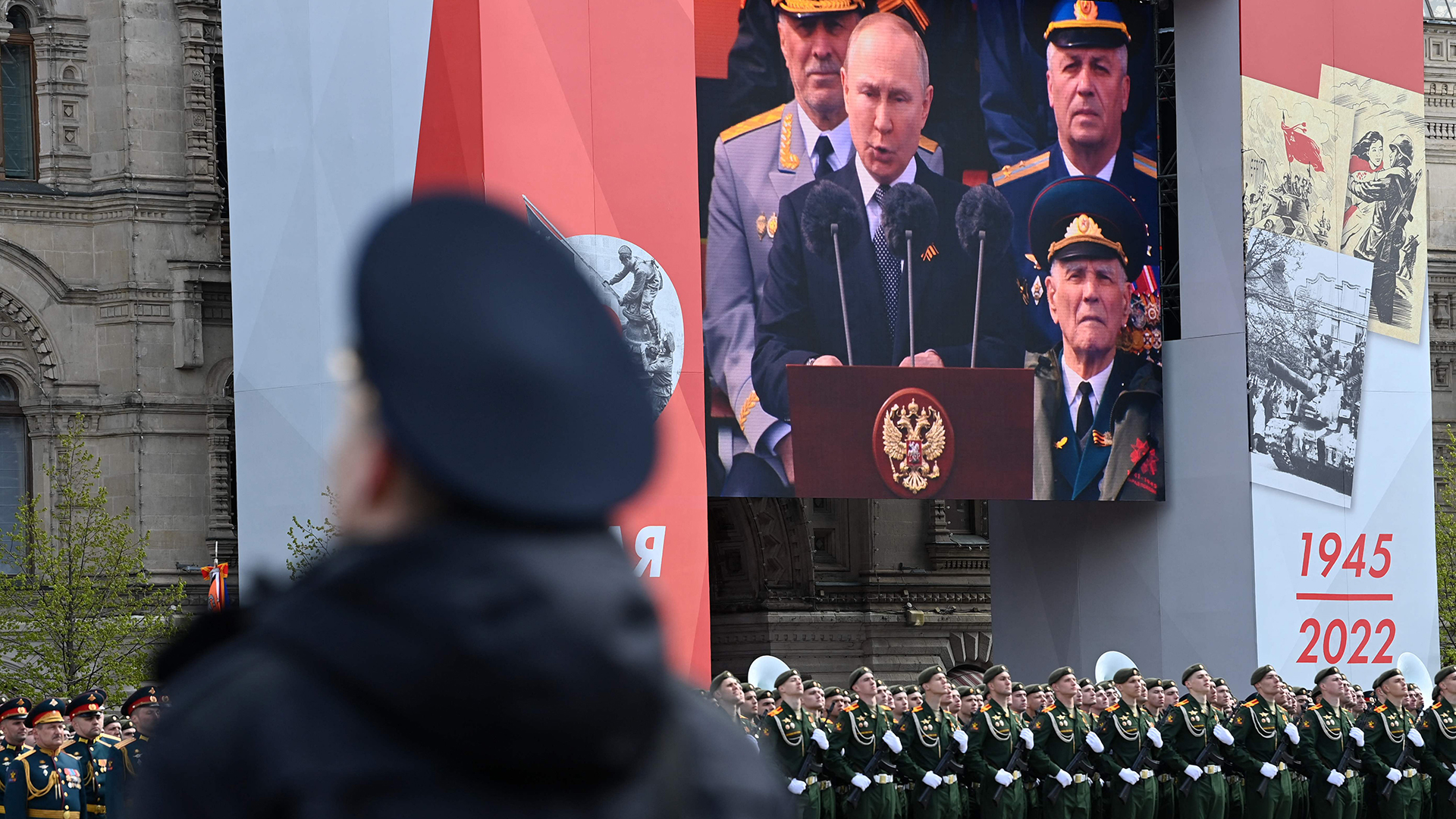 Auf einem Bildschirm ist zu sehen, wie der russische Präsident Wladimir Putin eine Rede hält.
