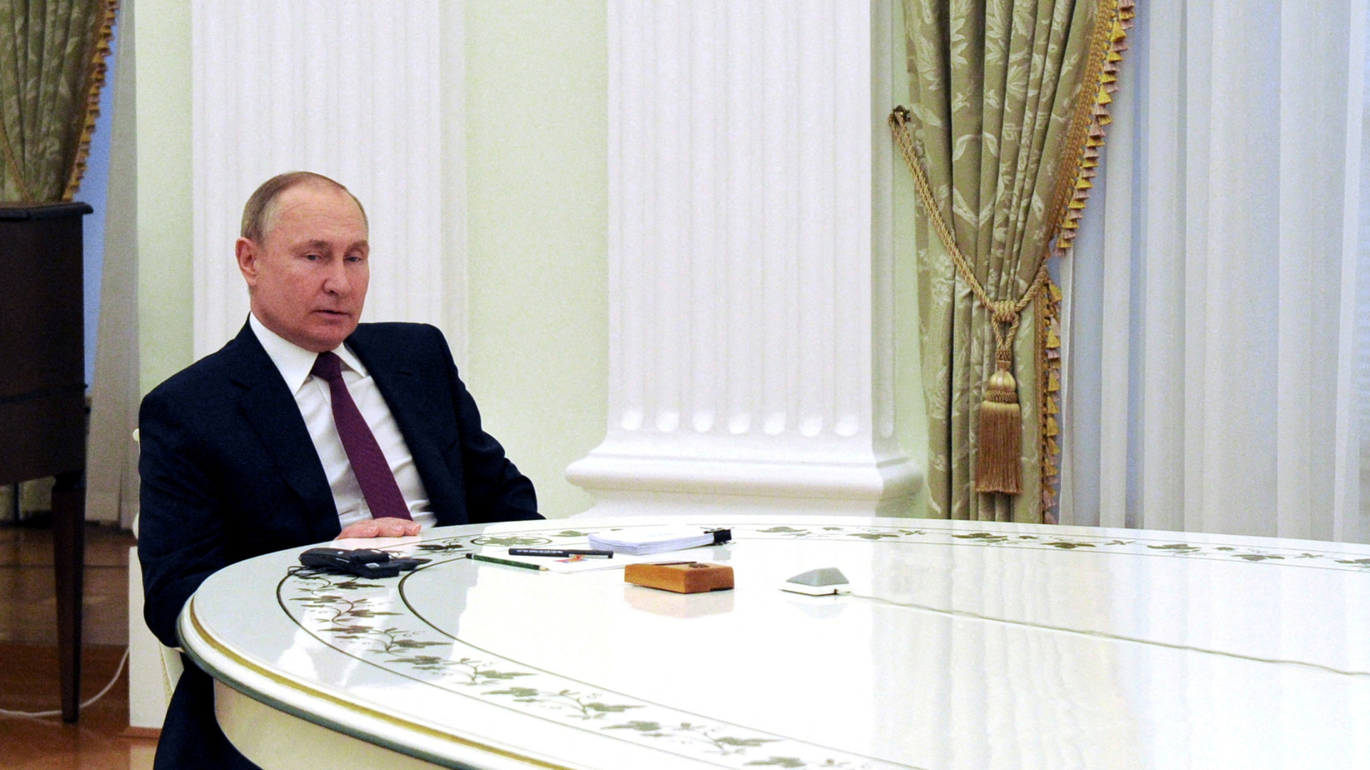 Russlands Präsident Putin sitzt an einem langen weißen Tisch im Kreml während des Gesprächs mit Bundeskanzler Scholz | via REUTERS