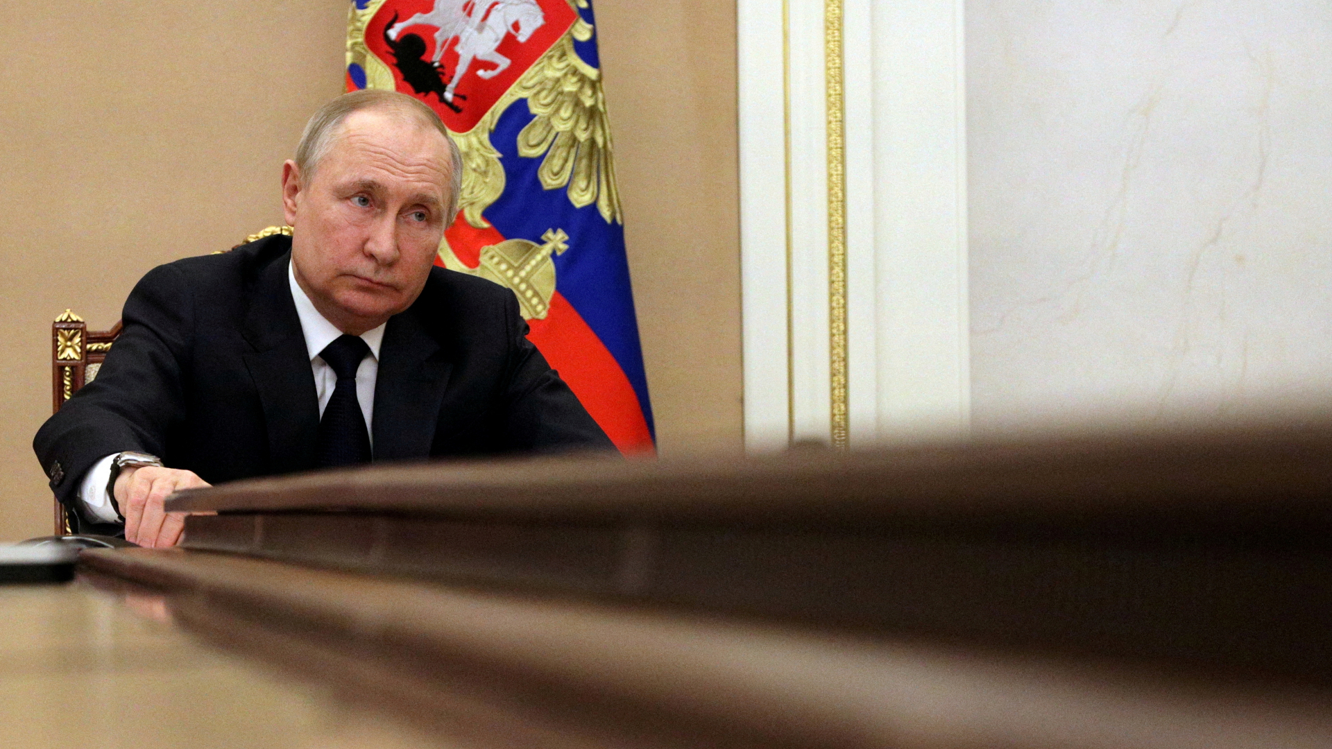 Wladimir Putin sitzt an einem langen Tisch. | via REUTERS