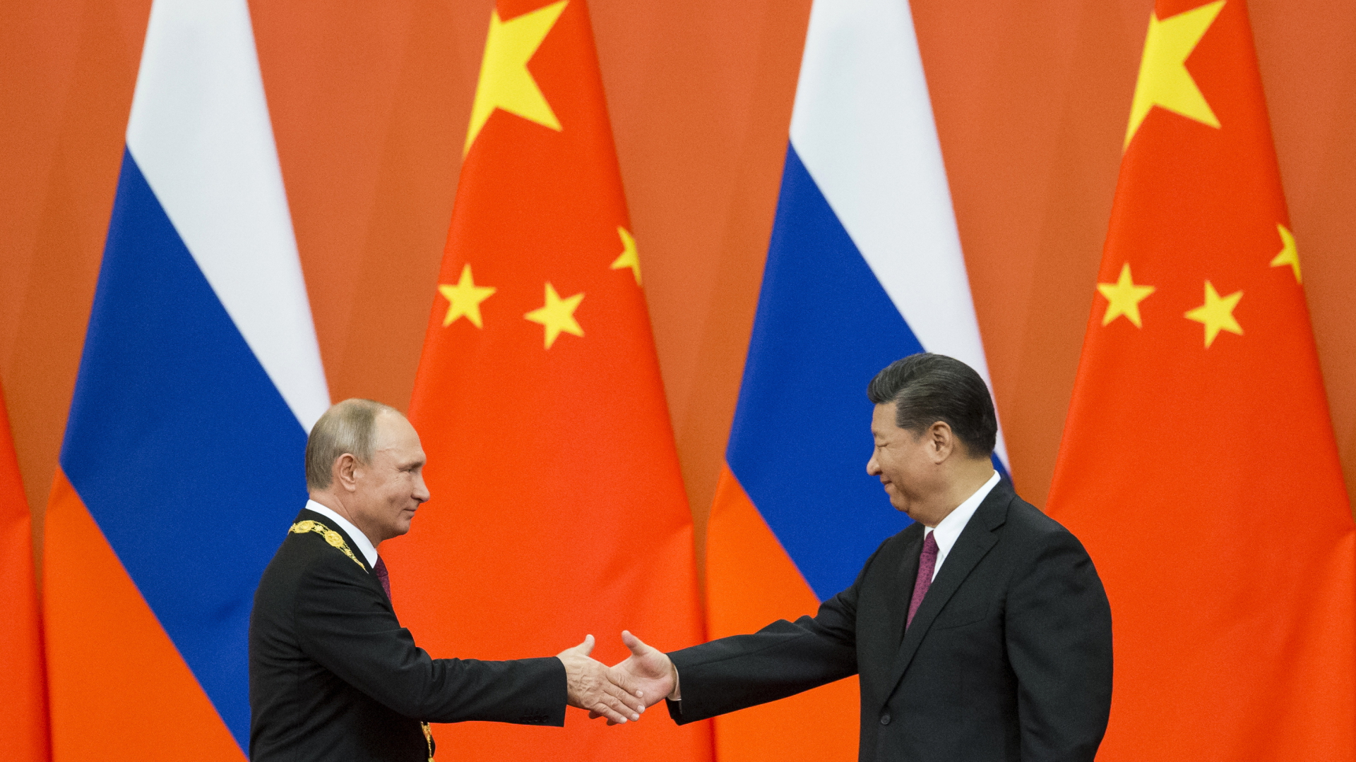 Xi Jinping (r), Präsident von China, und Wladimir Putin, Präsident von Russland, schütteln sich die Hände während einer Preisverleihungszeremonie in der Großen Halle des Volkes in 2018 (Archivbild).  | dpa
