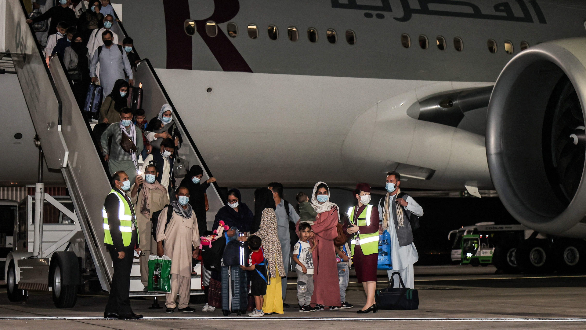 Passagiere aus Afghanistan vor einem Flugzeug von Qatar Airways am Flughafen von Do | AFP