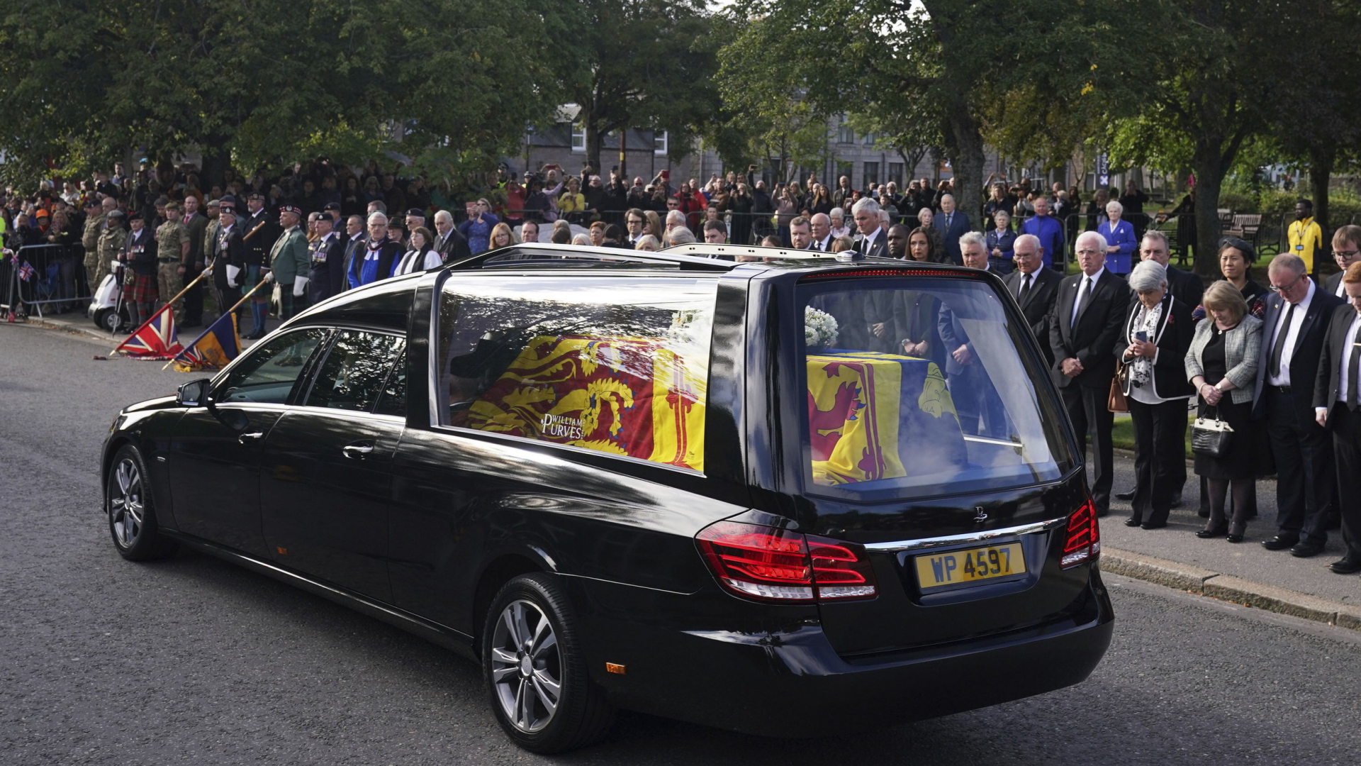 Der Sarg mit dem Leichnam der Queen wird nach Edinburgh übergeführt. Am Straßenrand stehen trauernde Menschen. | AP