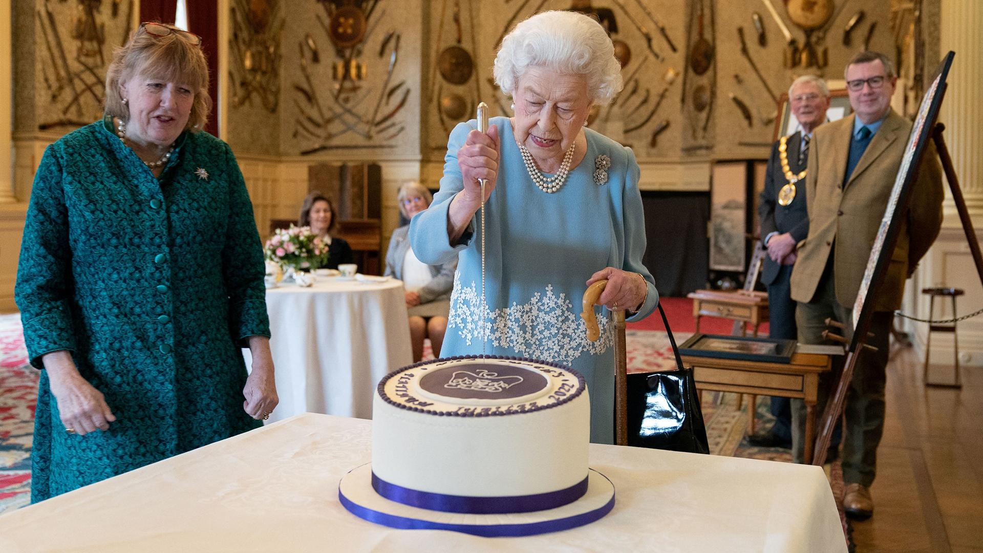 Die britische Königin Elizabeth schneidet eine Torte an, um den Beginn des Platinjubiläums zu feiern. | REUTERS