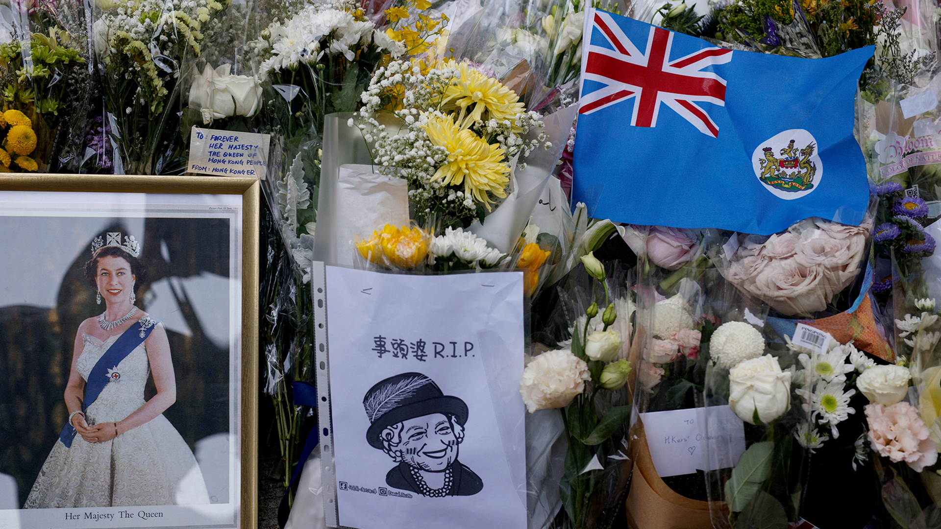 Die Kolonialflagge von Hongkong und Bilder von Queen Elizabeth vor dem britischen Generalkonsulat in Hongkong. | REUTERS