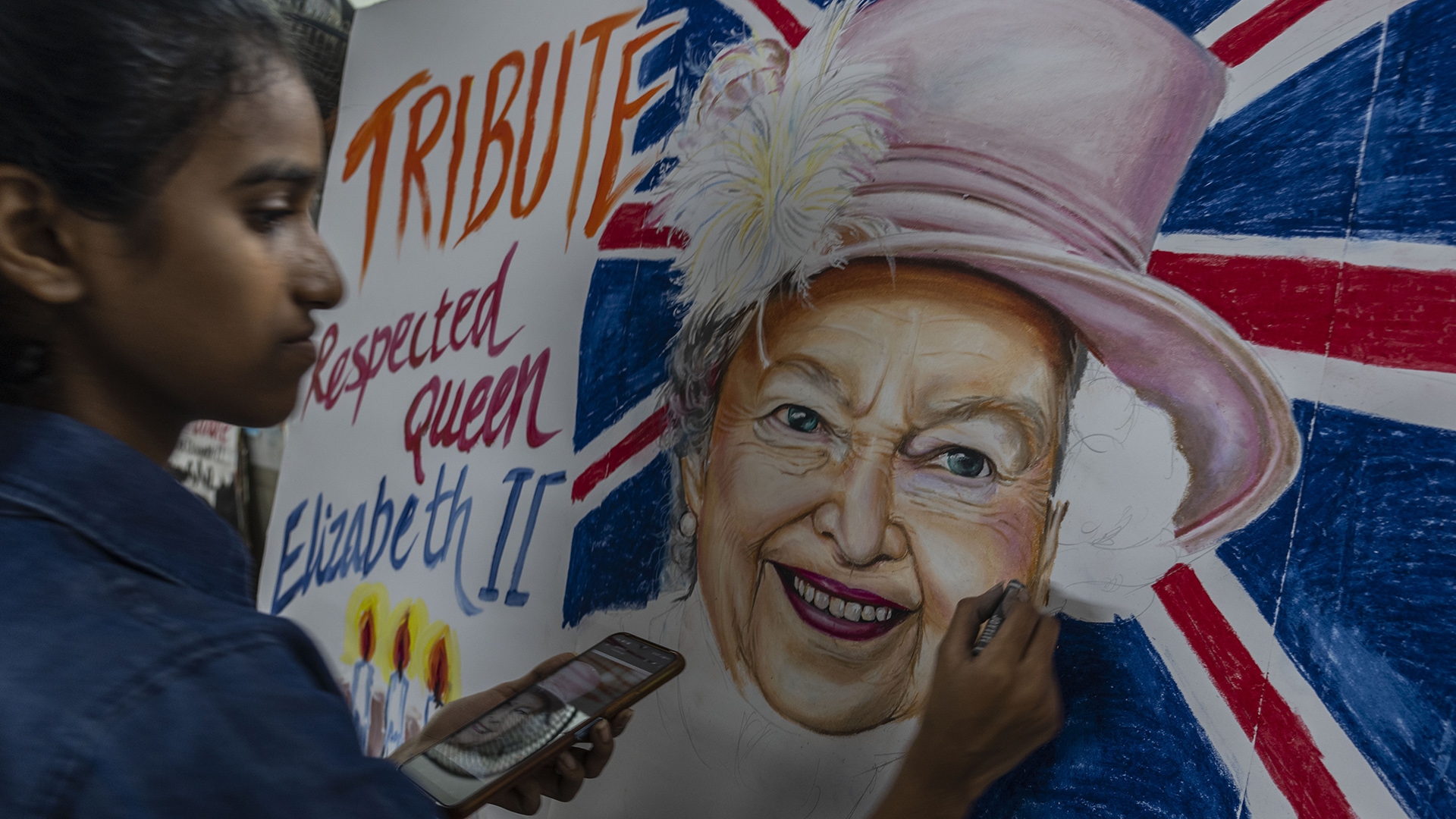 Eine Frau zeichnet Queen Elizabeth II. | dpa