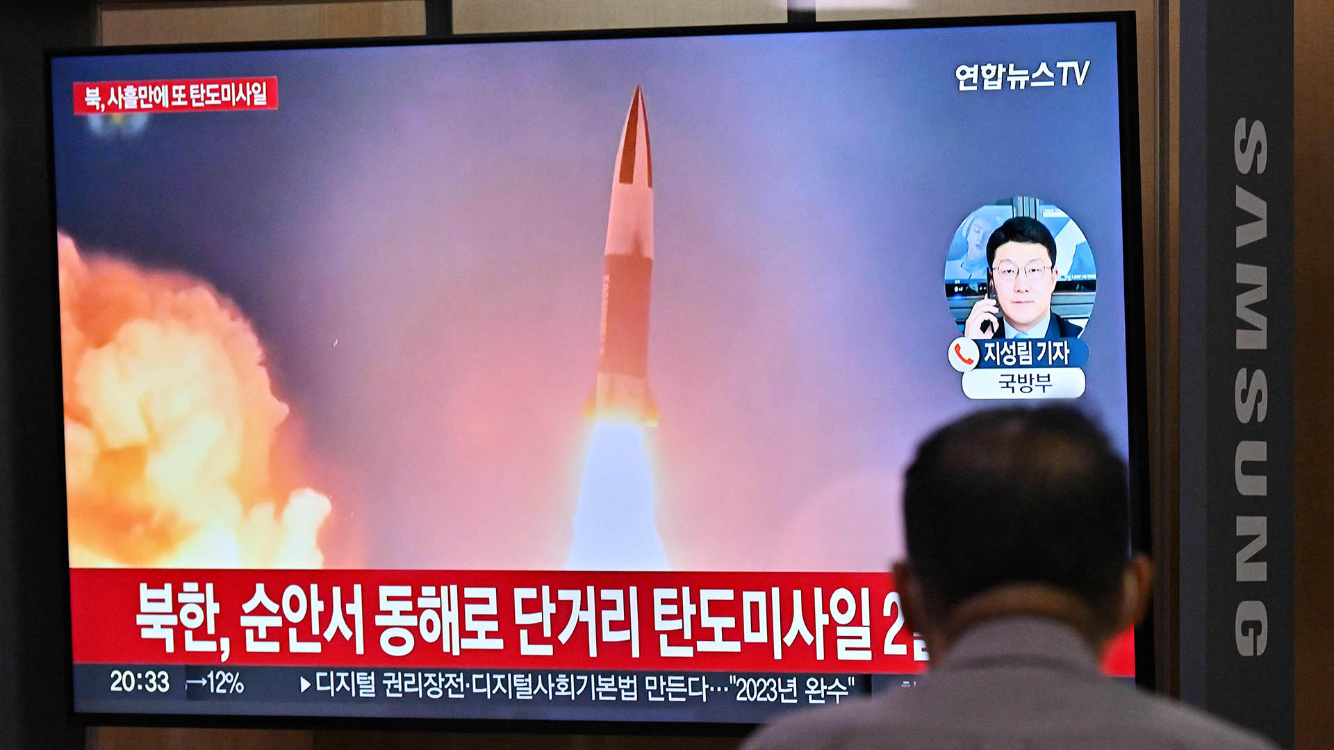 Ein Mann schaut auf einen Fernsehbildschirm, der eine Nachrichtensendung mit Aufnahmen eines nordkoreanischen Raketentests zeigt. | AFP