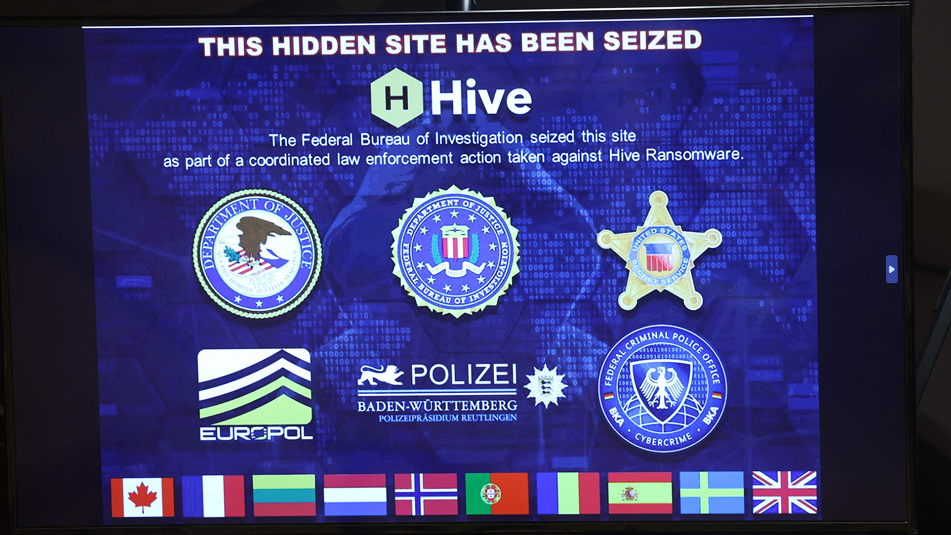 Ein Bild einer beschlagnahmten Ransomware-Website wird auf einer Pressekonferenz gezeigt.