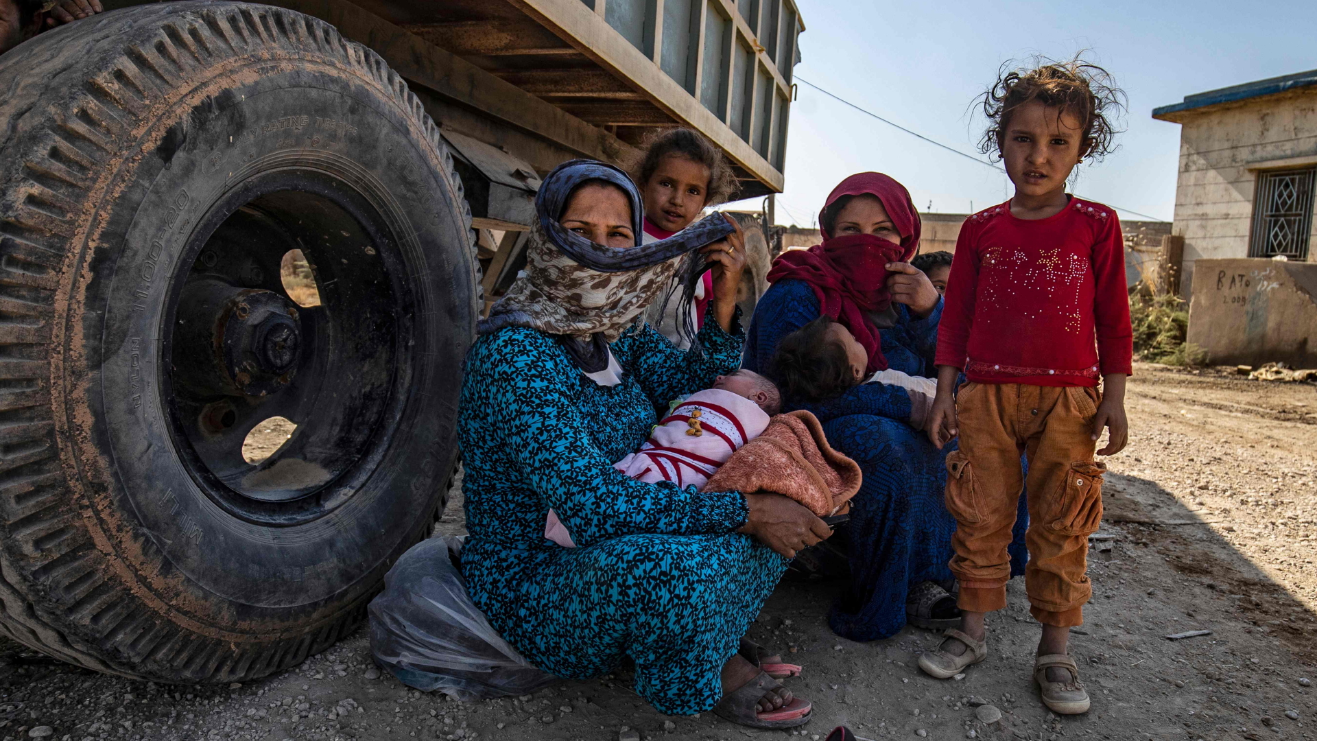 Frauen und Kinder sitzen im Schatten eines Lastwagens nahe der syrischen Stadt Hasake.  | AFP