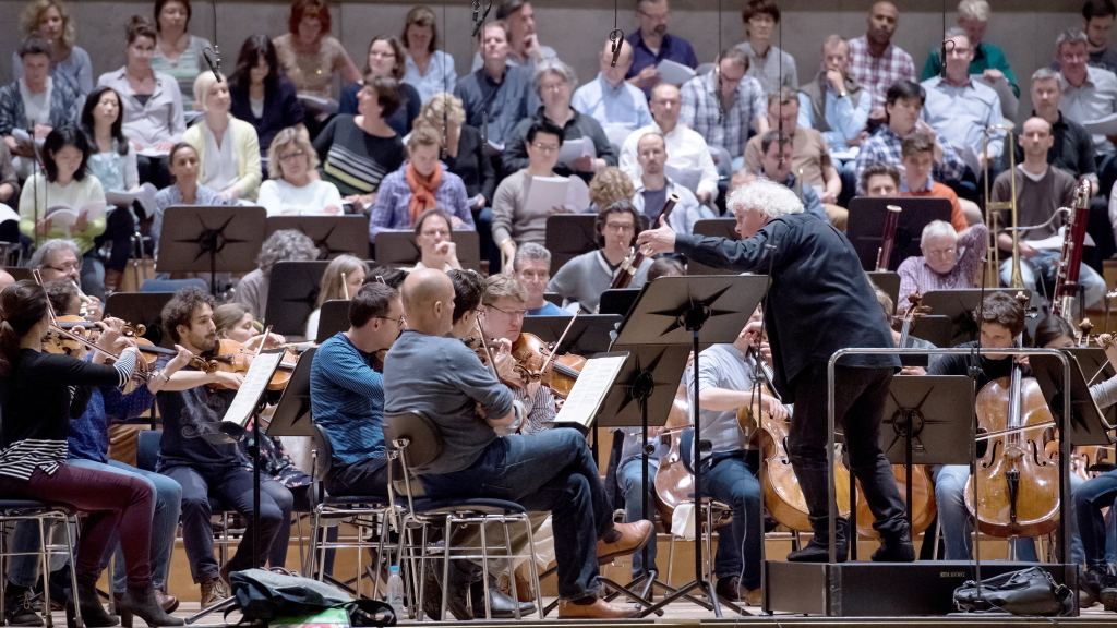 Der Dirigent Simon Rattle dirigiert in München bei einer Protestaktion den Chor und das Symphonieorchester des Bayerischen Rundfunks. 