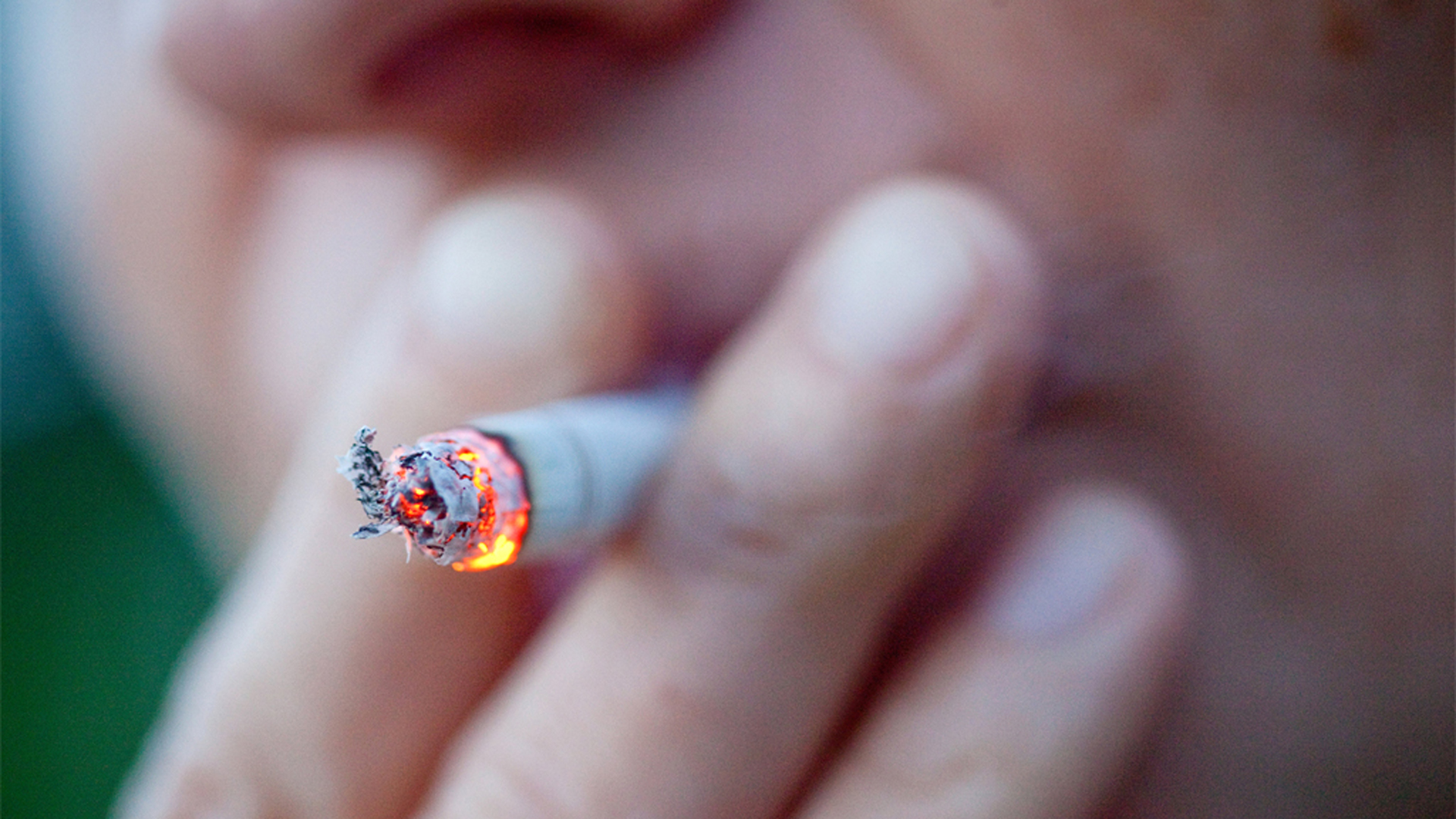 Silhouette eines Rauchers, der sich eine Zigarette anzündet.