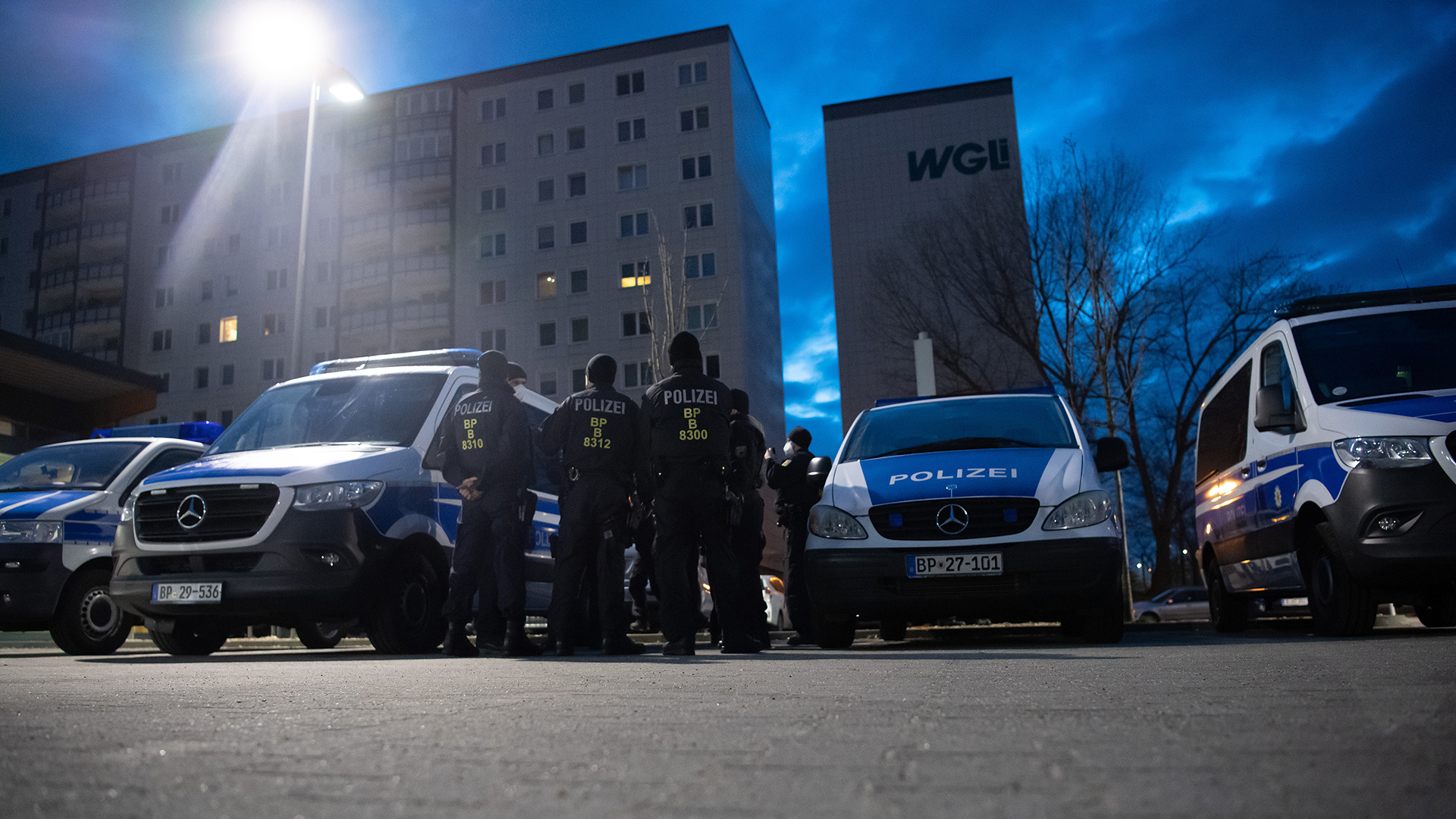 Einsatzkräfte der Bundespolizei stehen in Berlin-Lichtenberg auf einem Parkplatz und bereiten sich auf eine Razzia vor. | dpa