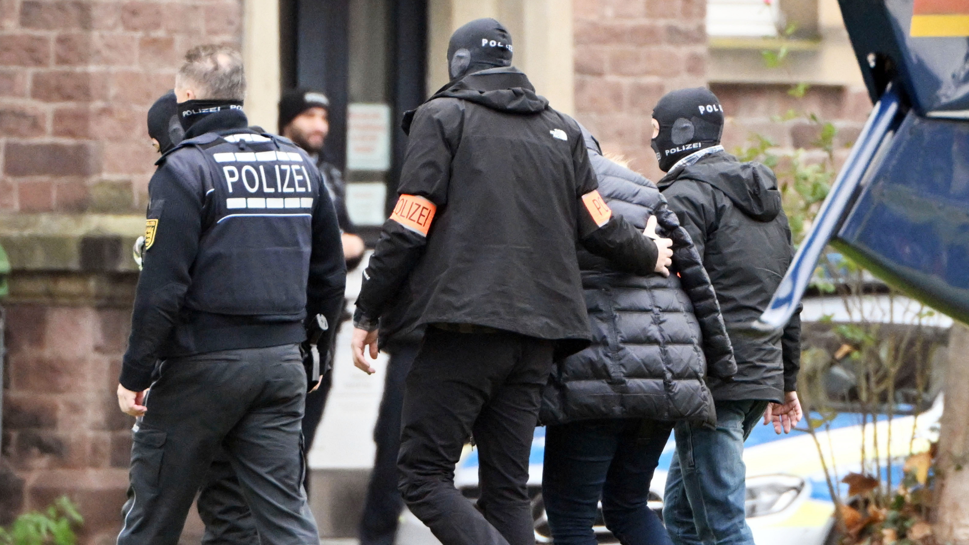 Polizisten führen nach einer Razzia im Reichsbürgermilieu eine Person zum Bundesgerichtshof in Karlsruhe