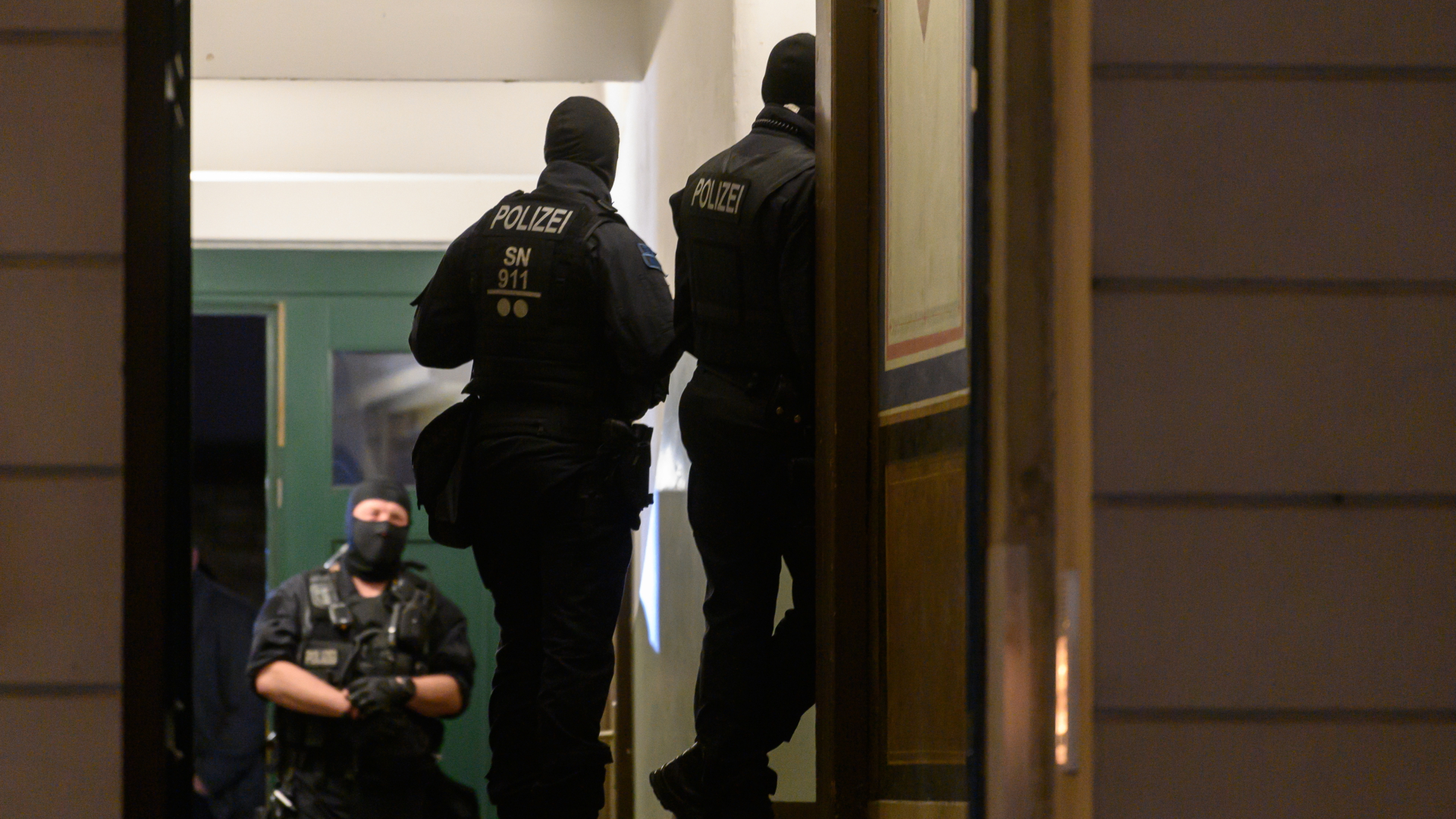 Polizisten stehen bei einer Razzia in einem Haus im Dresdner Stadtteil Pieschen. 