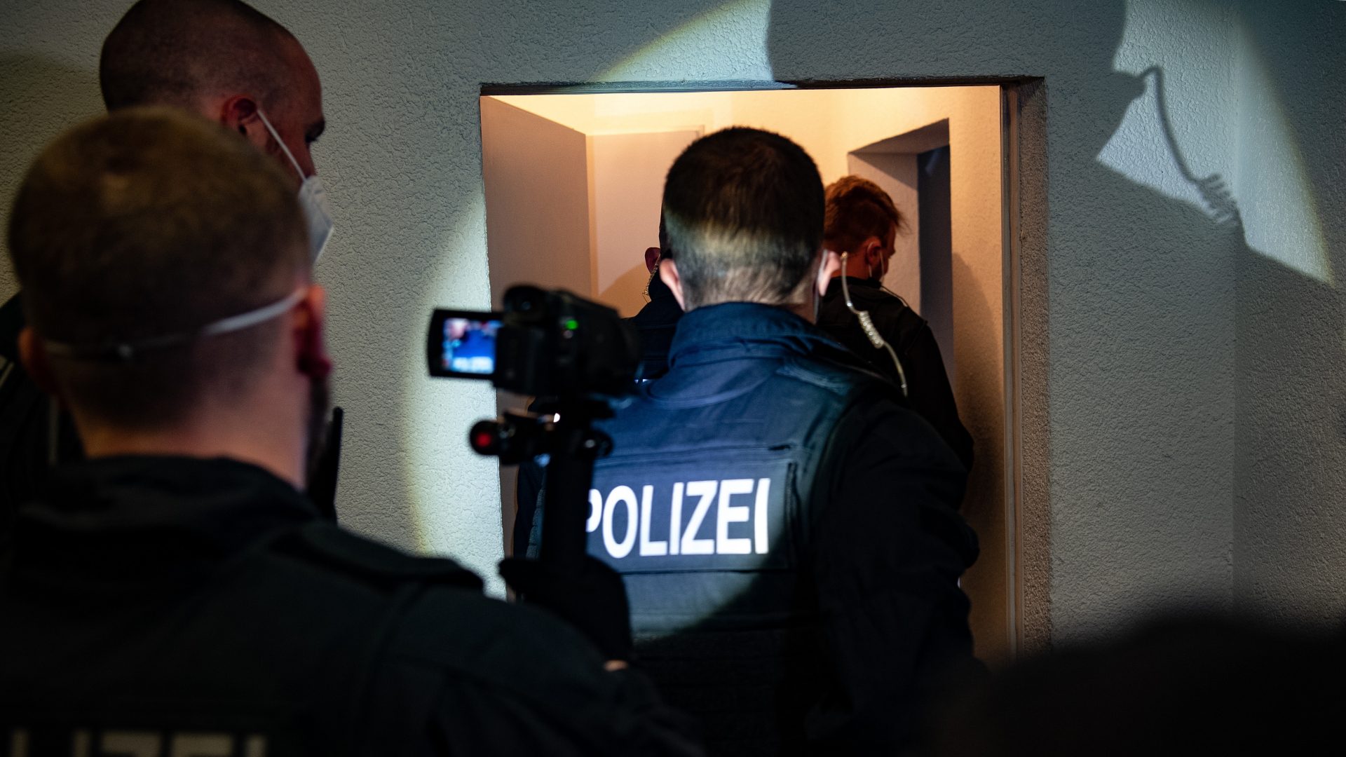 Bundespolizisten gehen bei einer Razzia gegen Schleuser in eine Wohnung. | dpa