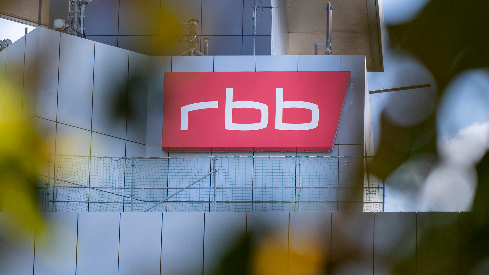Das Logo des öffentlichen Senders Rundfunk Berlin-Brandenburg (RBB) ist an der Fassade am Sitz des Senders in Berlin zu sehen. | dpa