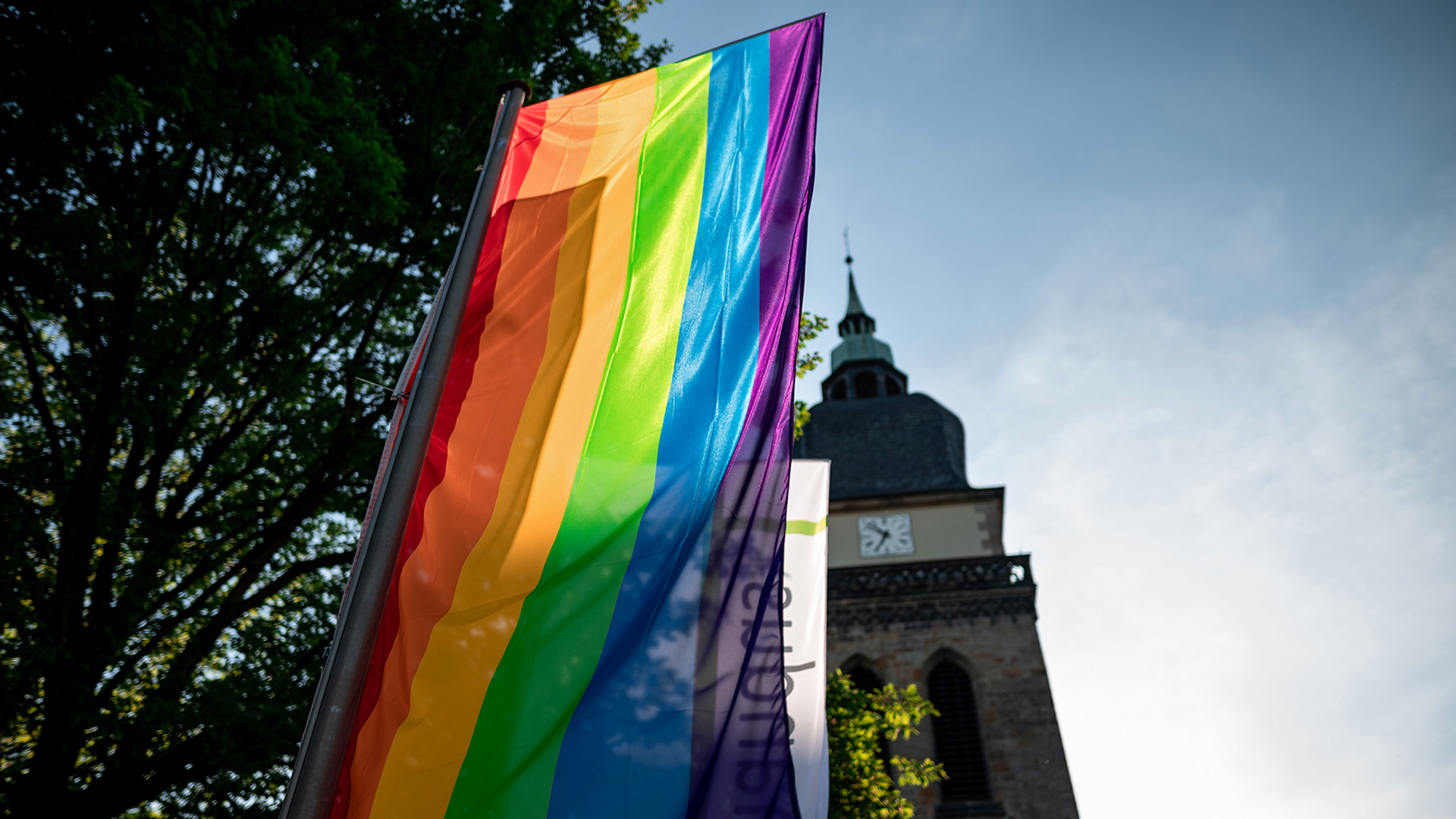 Eine Regenbogenfahne weht vor der Pfarrkirche in Datteln.