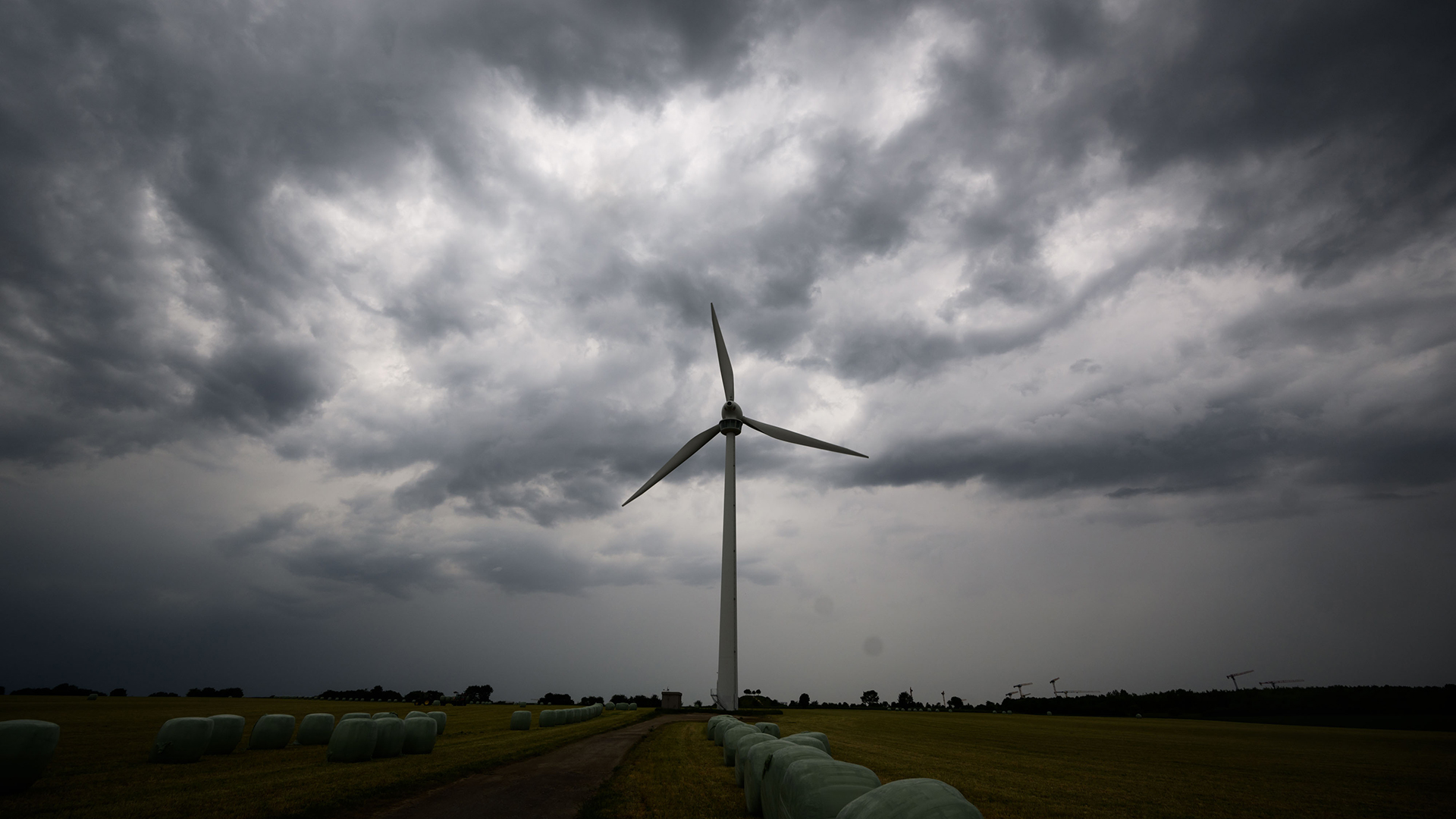 Eine Gewitterfront zieht vor einem Windrad am Himmel bei Hannover (Niedersachsen) auf. | dpa