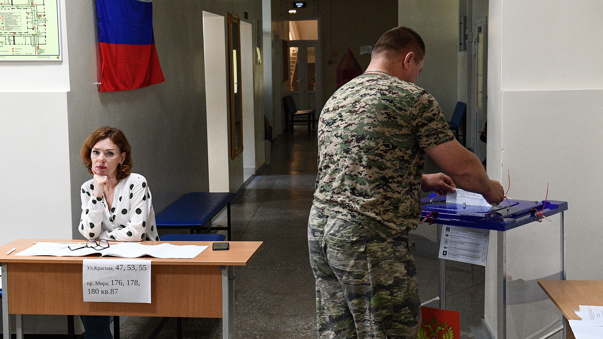 Das Bild von der russischen Staatsagentur Tass zeigt einen Mann bei der Stimmabgabe in einem Wahllokal.