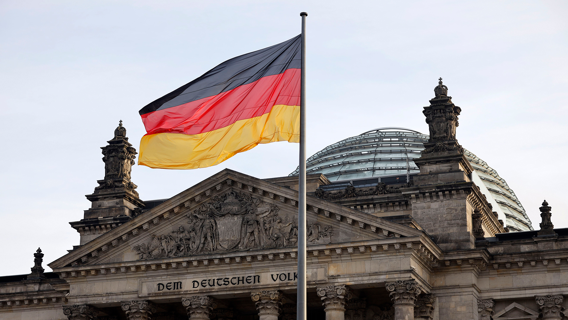 Die Deutschlandflagge weht vor dem Reichstag in Berlin. | picture alliance / Geisler-Fotop