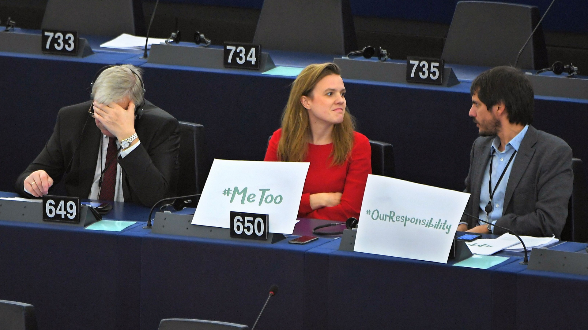 EU-Parlamentarierin Terry Reintke sitzt mit einem #metoo-Plakat zwischen zwei Kollegen | AFP