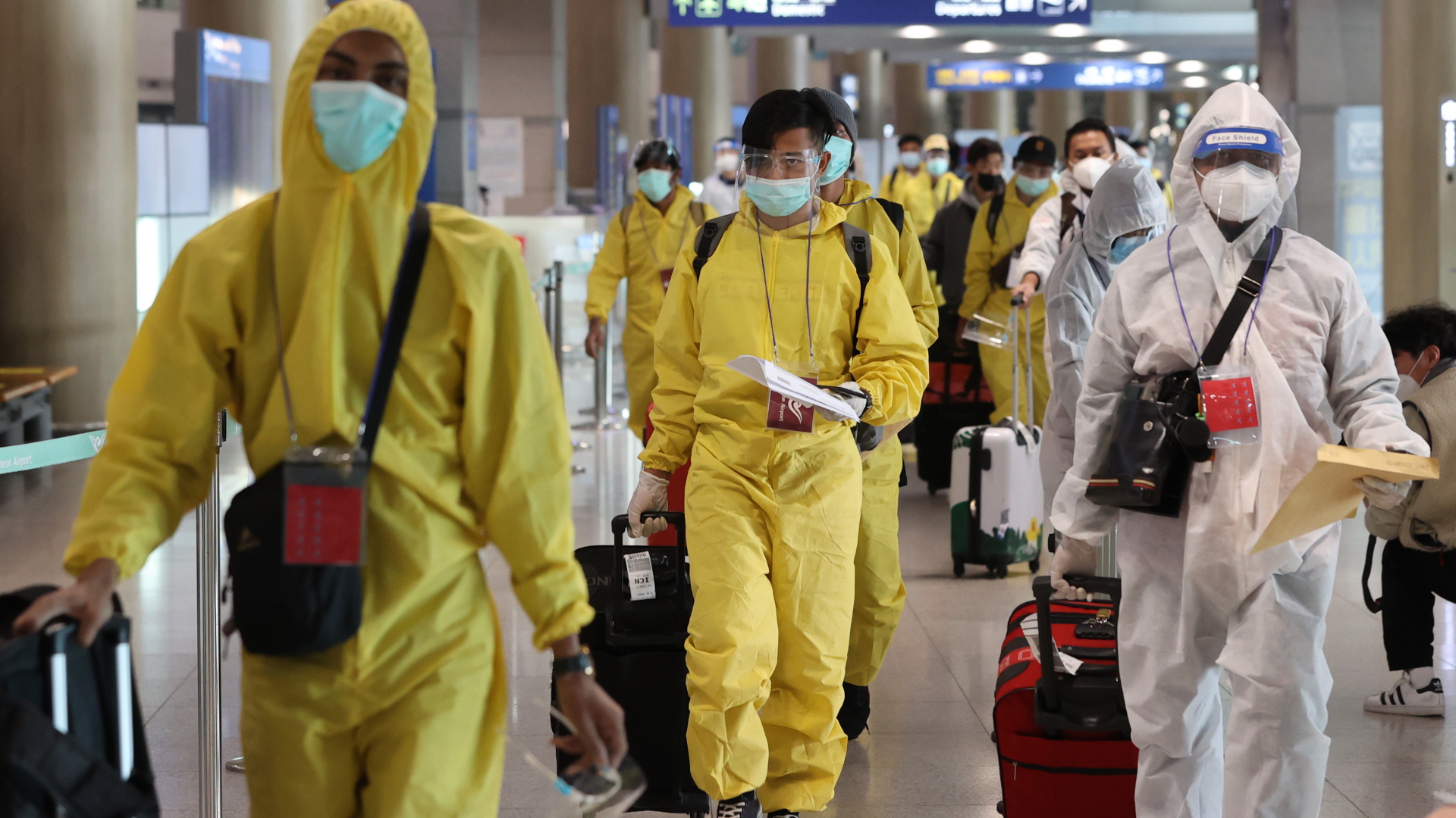 Reisende in Schutzanzügen am Flughafen in Südkorea | EPA