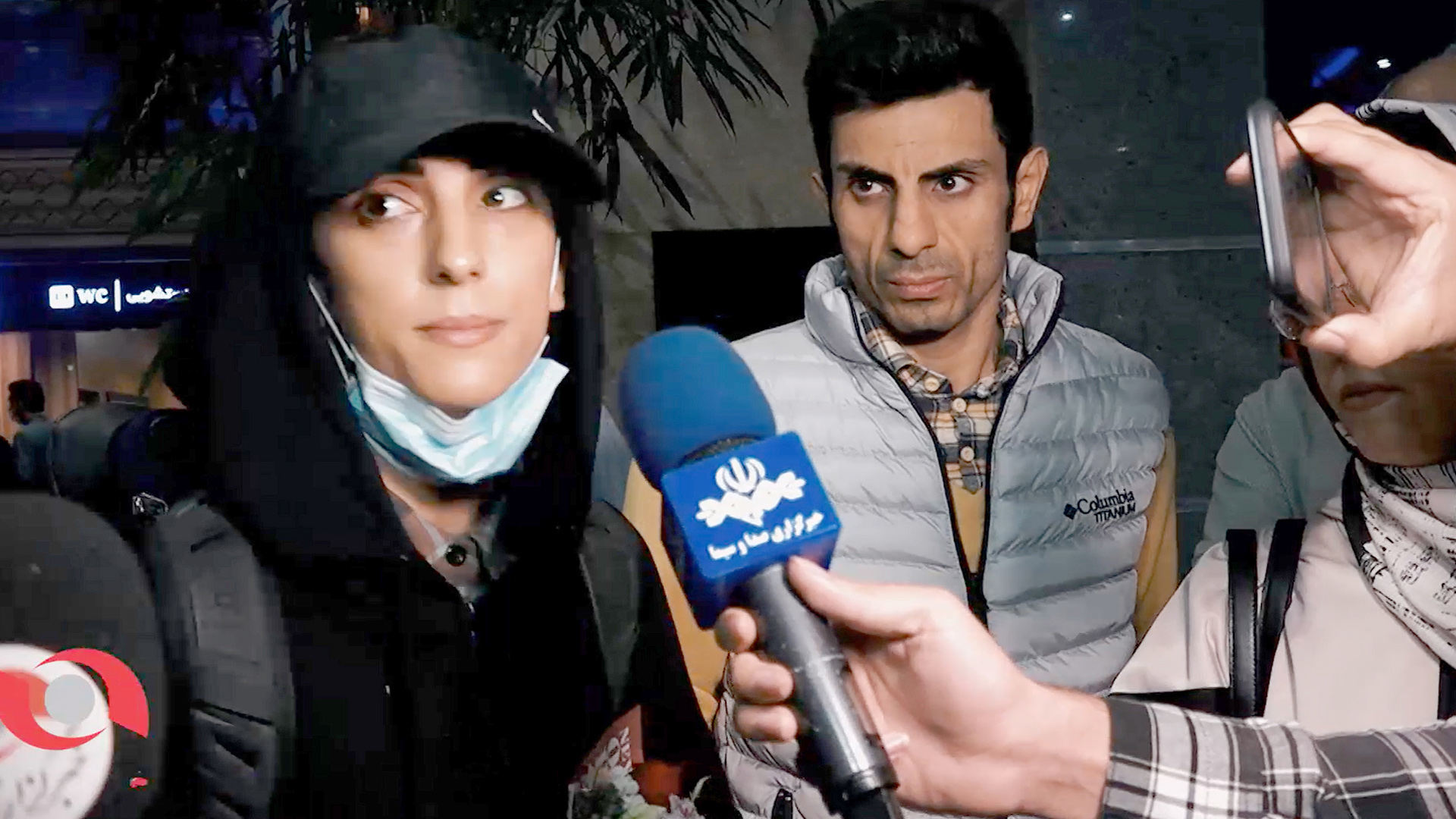 Elnas Rekabi (links) spricht am Flughafen Teheran mit Journalisten, Iran. | EPA