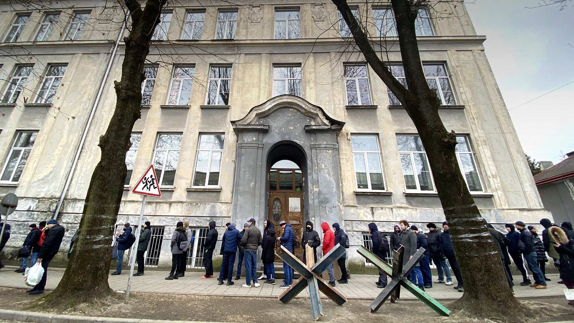 Männer stehen in einer Schlange vor einem Rekrutierungsbüro in Lwiw. | picture alliance/dpa/MAXPPP