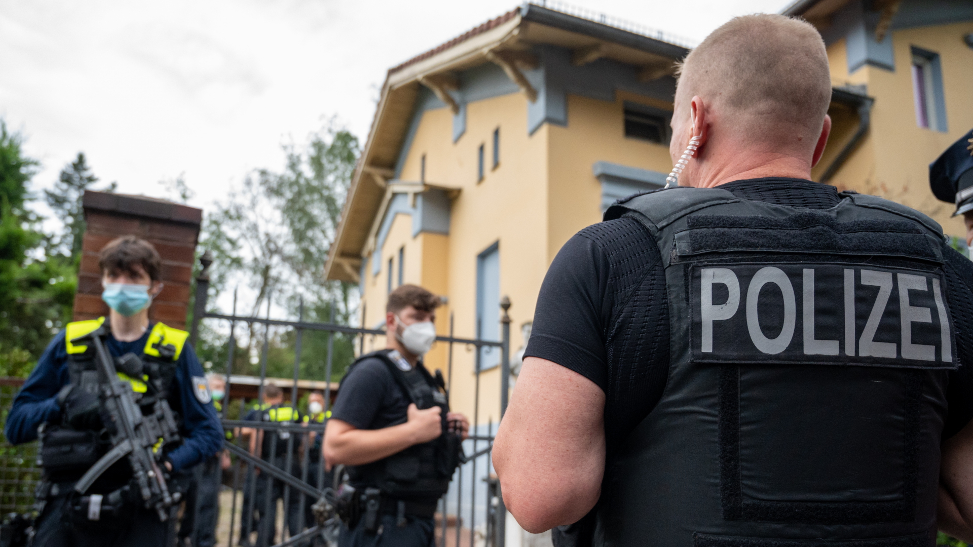 Polizisten stehen vor einem Wohnhaus von Mitgliedern des bekannten Remmo-Clans in Berlin Neukölln. | dpa