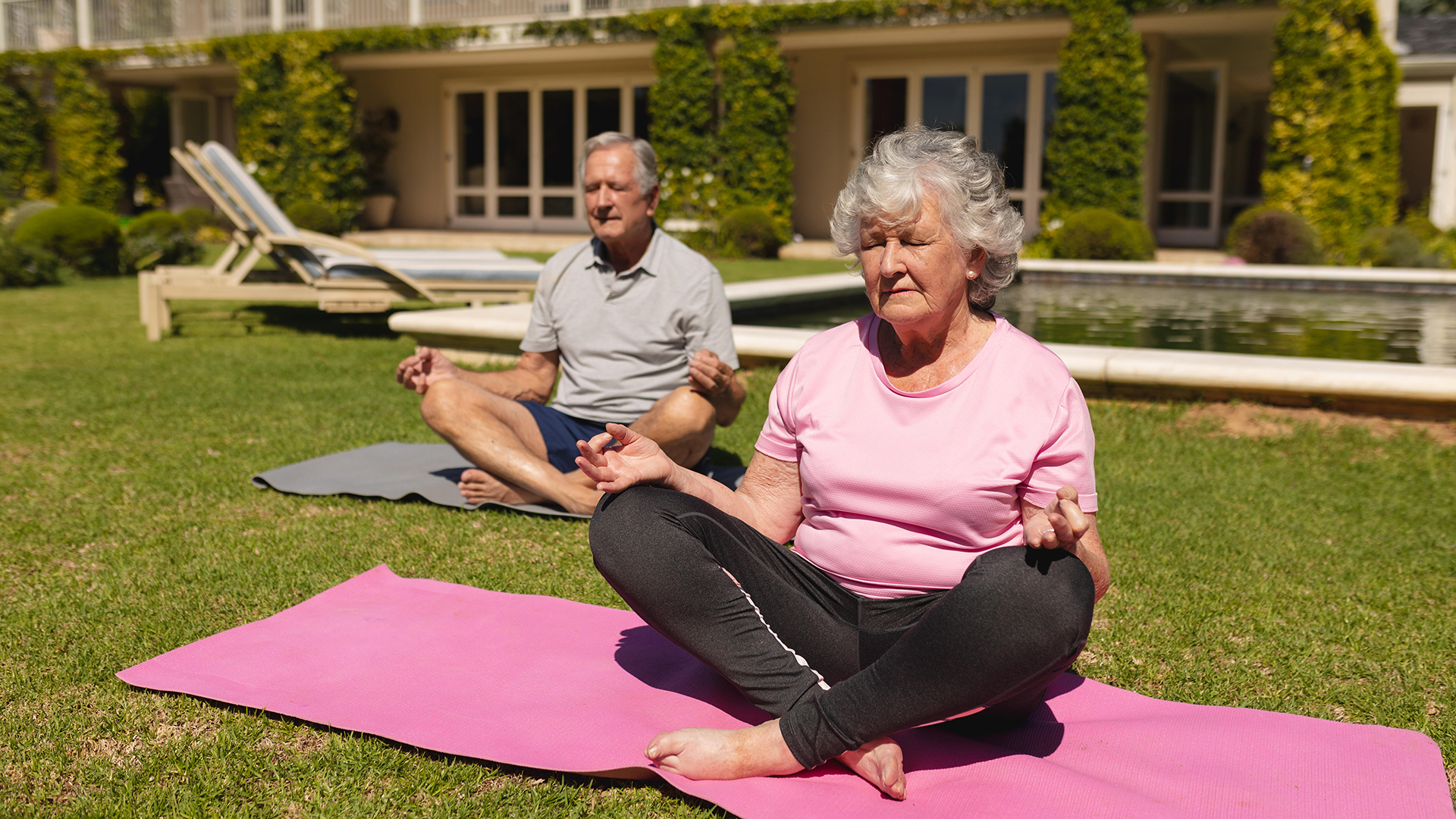 Ein Älteres Paar, das Yoga praktiziert und im sonnigen Garten meditiert.  | picture alliance / Zoonar