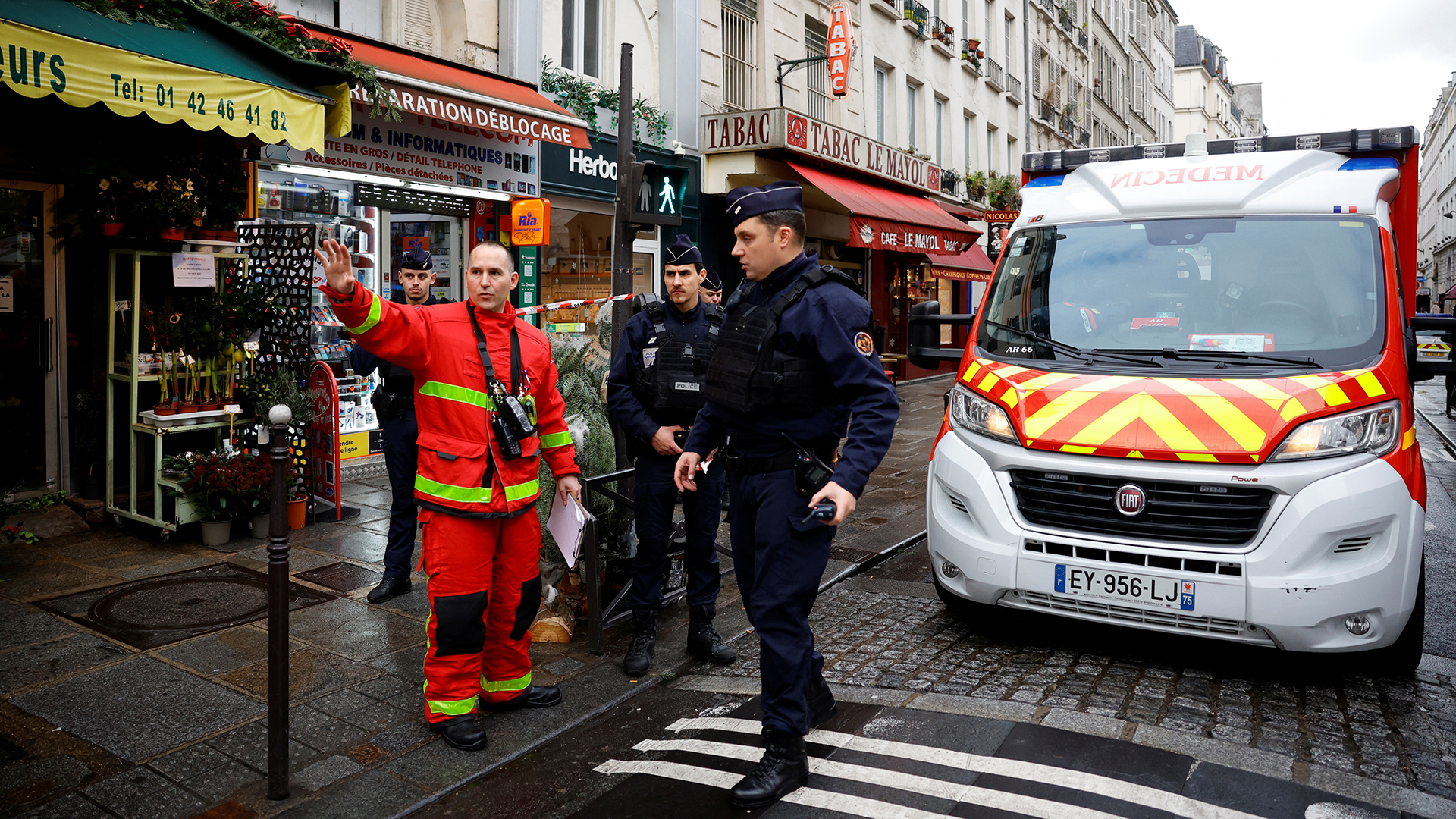 Französische Polizisten und Feuerwehrleute sichern eine Straße in Paris. | REUTERS