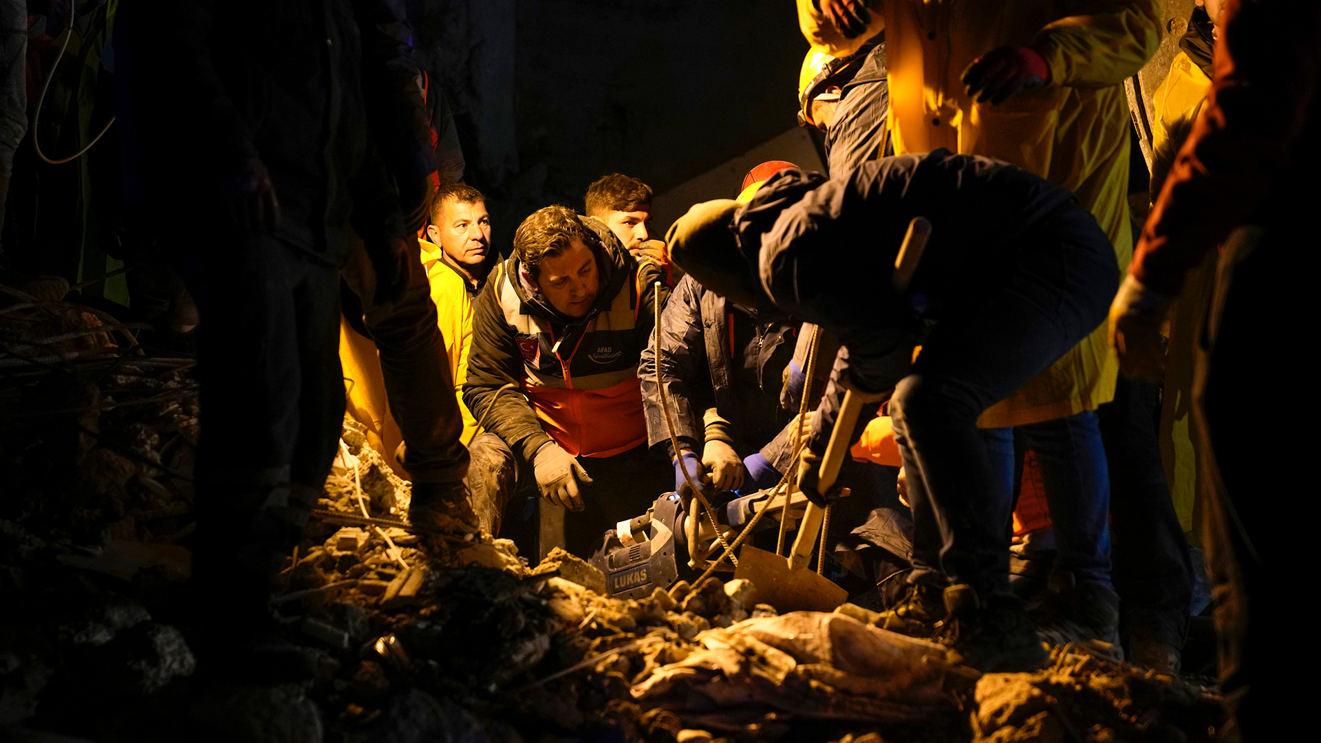 Rettungskräfte suchen in den Trümmern nach Menschen in einem zerstörten Gebäude in Adana (Türkei).