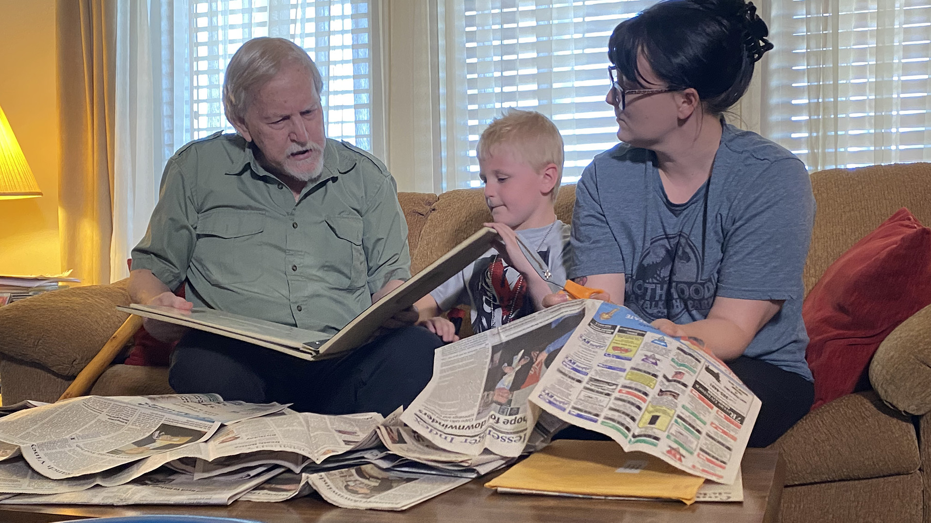 Bill Reynolds mit seiner Schwiegertochter Misty und dem Enkel Ian sitzen auf einem Sofa. | ARD Washington