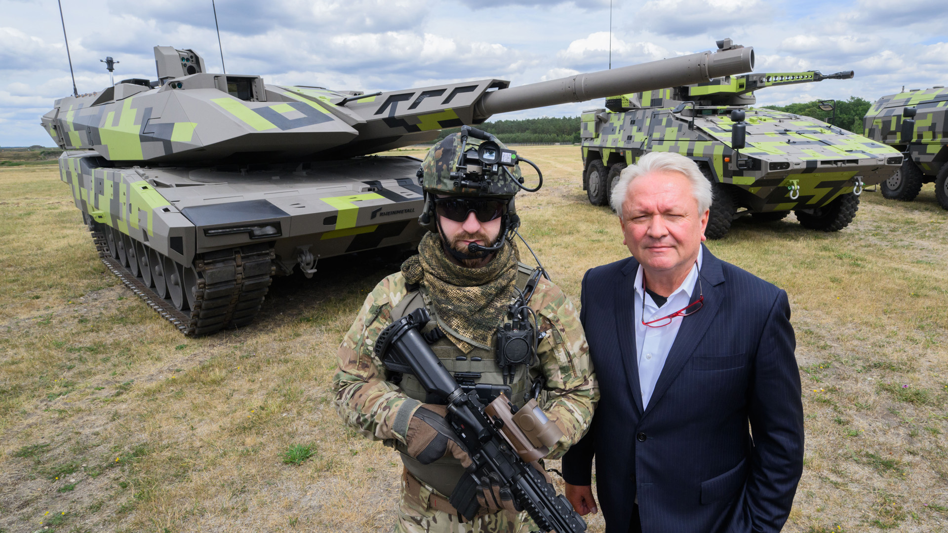 Rheinmetall-Vorstand Armin Papperger steht mit einem Mann in Kampfausrüstung vor einem Kampfpanzer des Typs Panther KF51 | picture alliance/dpa