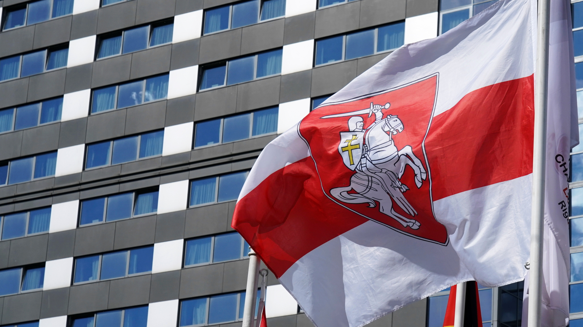 Vor einem Mannschaftshotel in Riga weht die von der Opposition genutzte historische Fahne von Belarus. | REUTERS