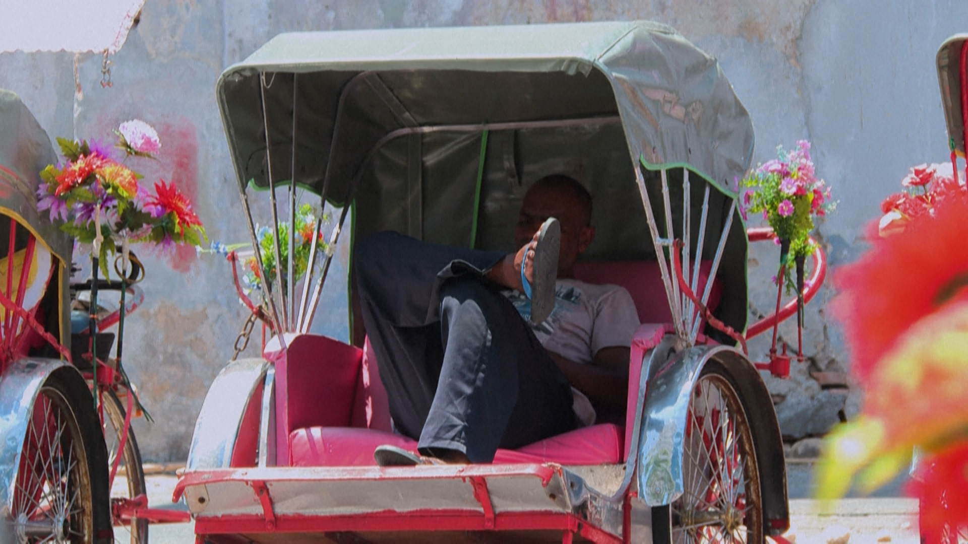 Ein Mann sitzt in einer Rikscha.