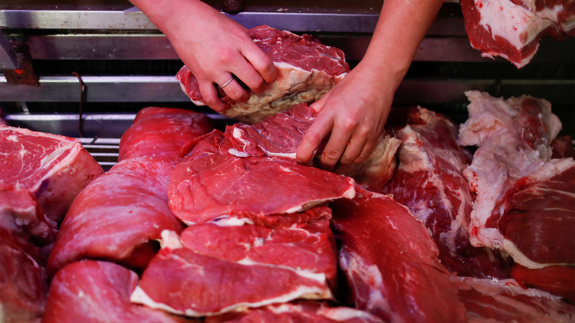 Ein Mann sortiert rohe Fleischstücke argentinischer Rinder | REUTERS