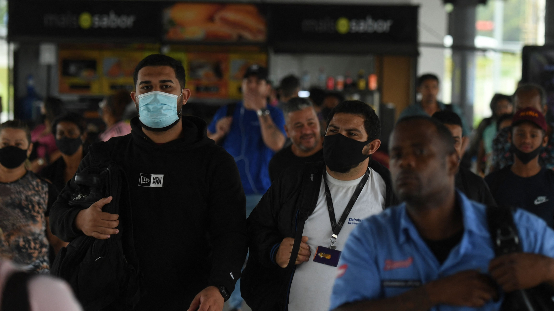 Passanten mit und ohne Corona-Maske an einem Busbahnhof in Rio de Janeiro, Brasilien. | AFP