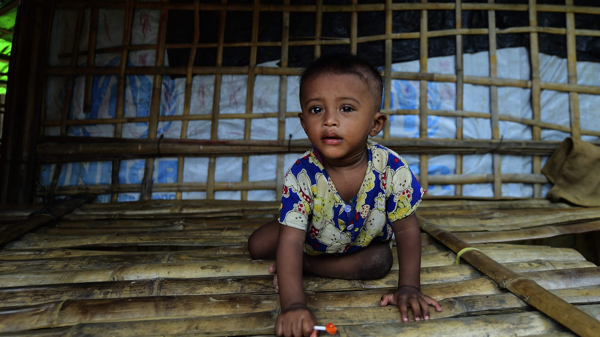 Ein Kind der Rohingya klettert in einem Flüchtlingslager in Bangladesch über Holzboden. | AFP