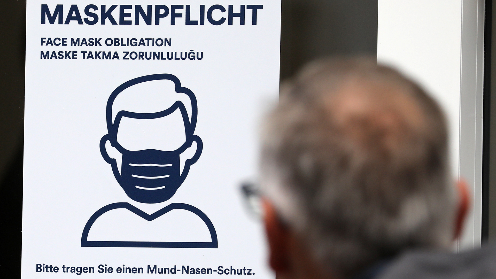Auf einem Aushang an einer Bankfiliale in der Rostocker Innenstadt steht in mehreren Sprachen "Maskenpflicht Bitte tragen Sie einen Mund-Nasen-Schutz". | picture alliance/dpa/dpa-Zentral