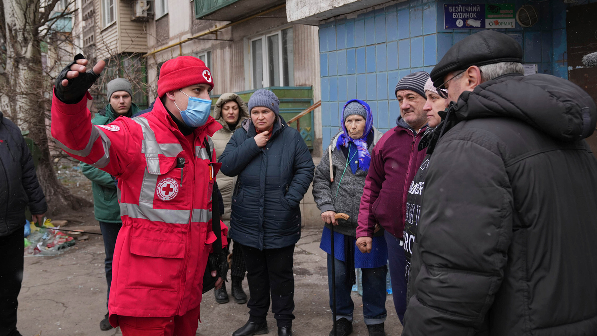 Mitarbeiter des Roten Kreuzes neben einem Wohnhaus in Mariupol, Ukraine (Archivbild 07.03 2022) | AP
