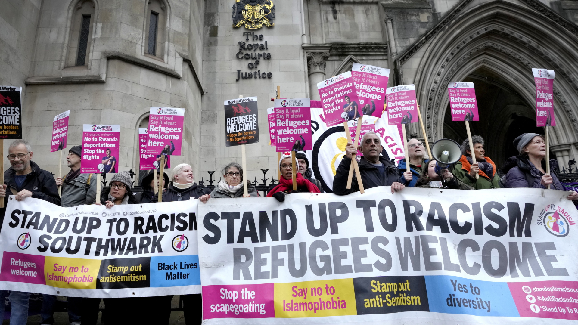 "Stand Up To Racism"-Aktivisten stehen mit Schildern vor dem Londoner High Court.  | AP