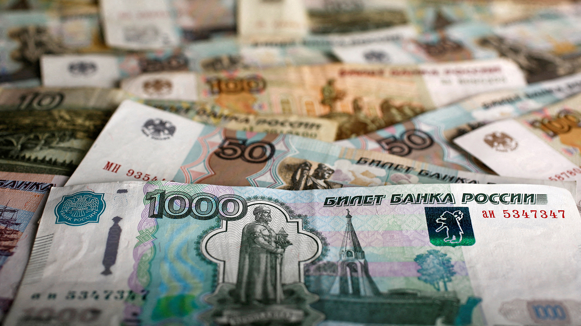Russische Rubel-Banknoten verschiedener Stückelungen liegen auf einem Tisch. | REUTERS