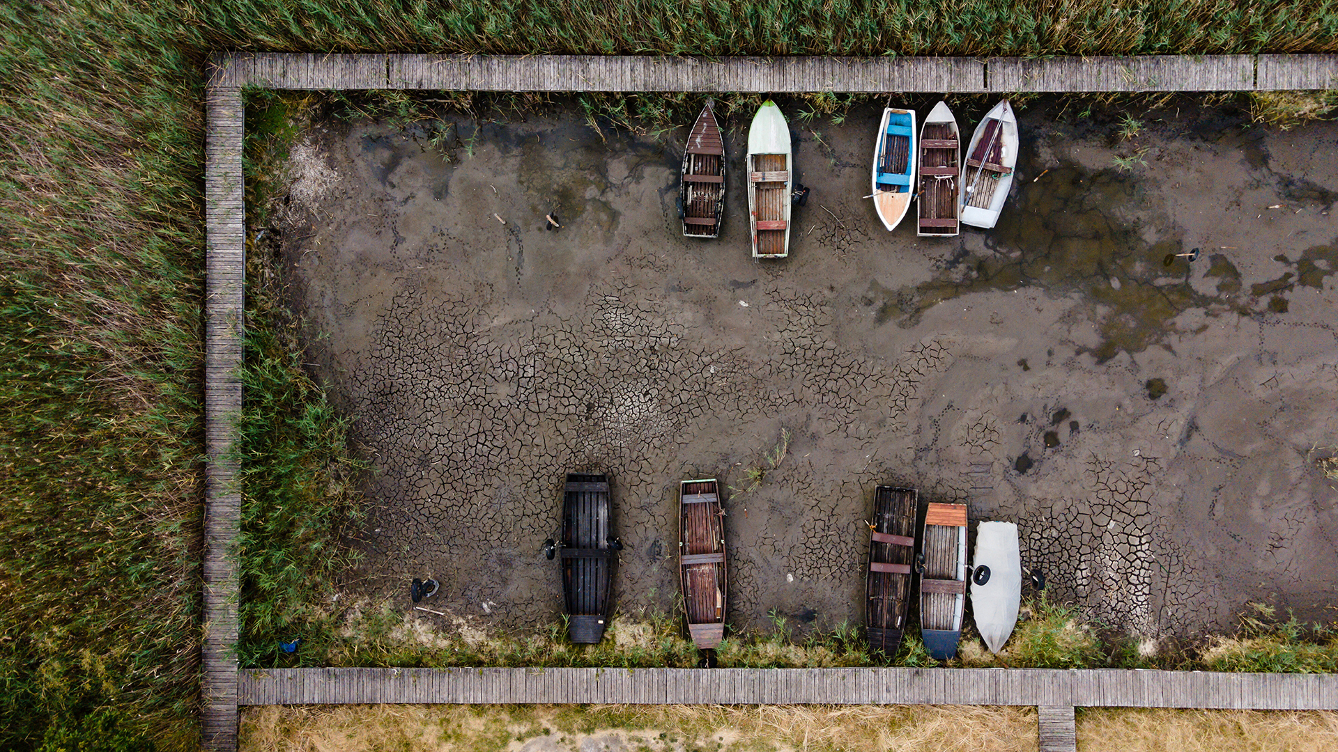 Ruderboote liegen auf dem Boden des ausgetrockneten Velencer Sees. | dpa