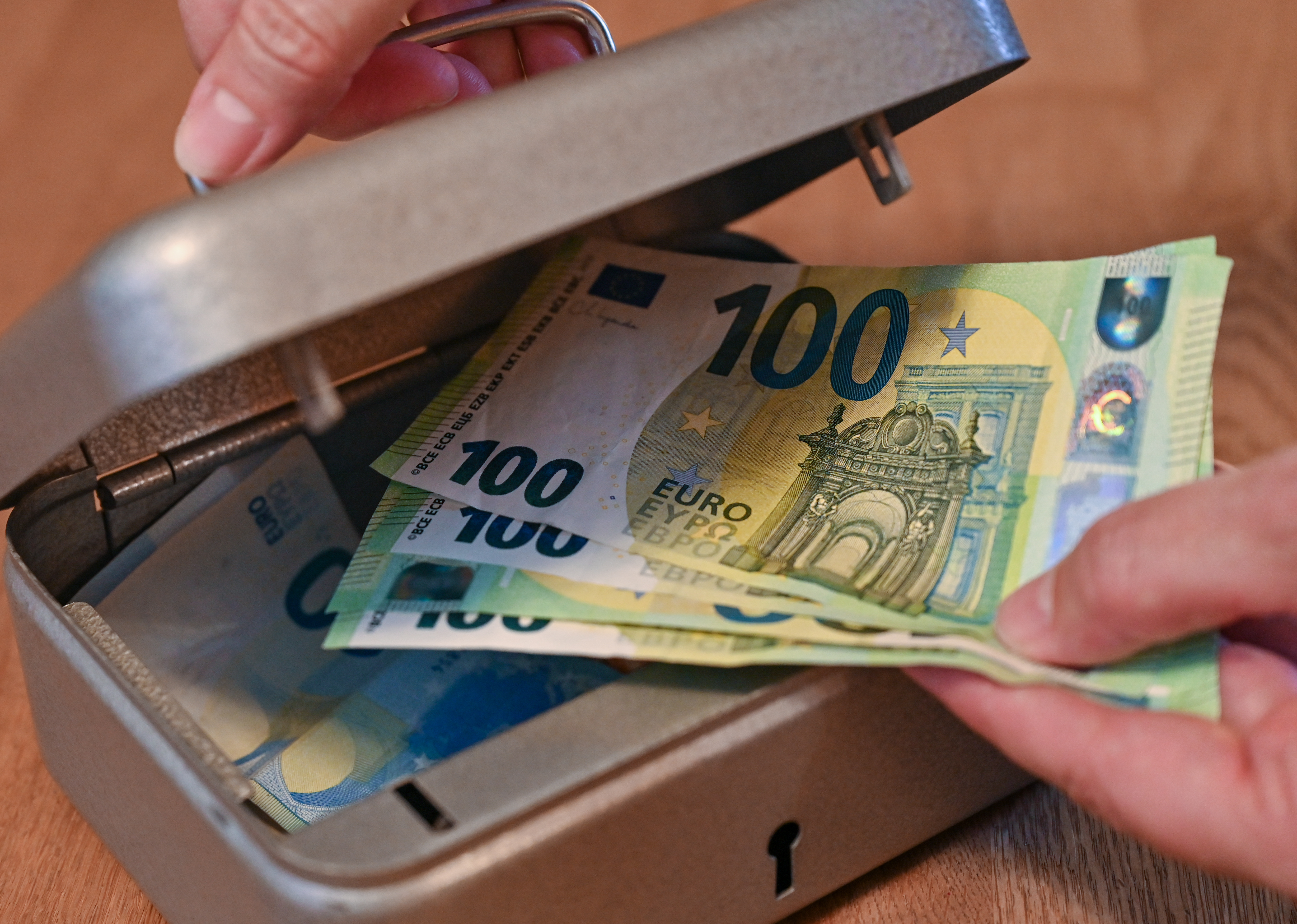 Eine Person holt Eurobanknoten aus einer kleinen Geldkassette. | picture alliance/dpa/dpa-Zentralbild