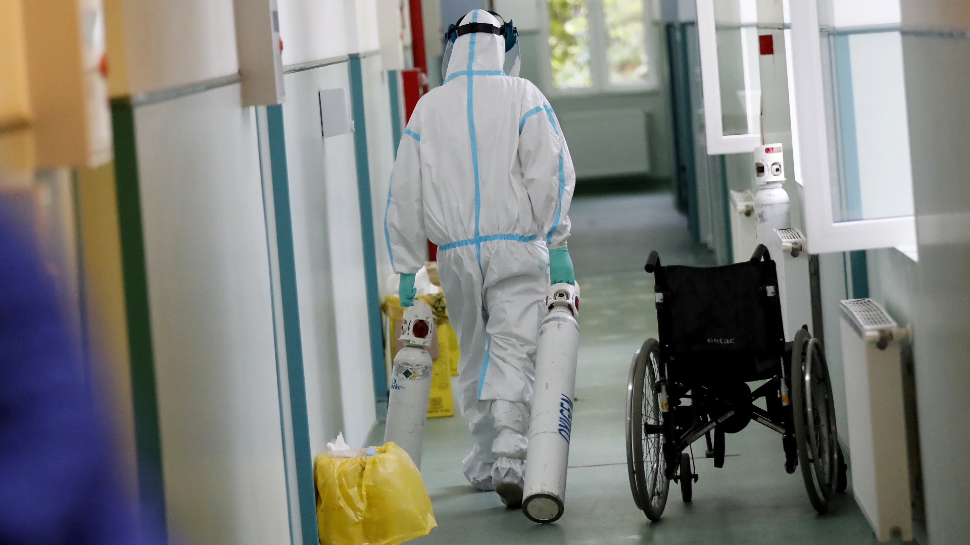 Ein Krankenhausmitarbeiter geht mit zwei neuen Sauerstoffflaschen über den Flur eines Krankenhauses in Bukarest